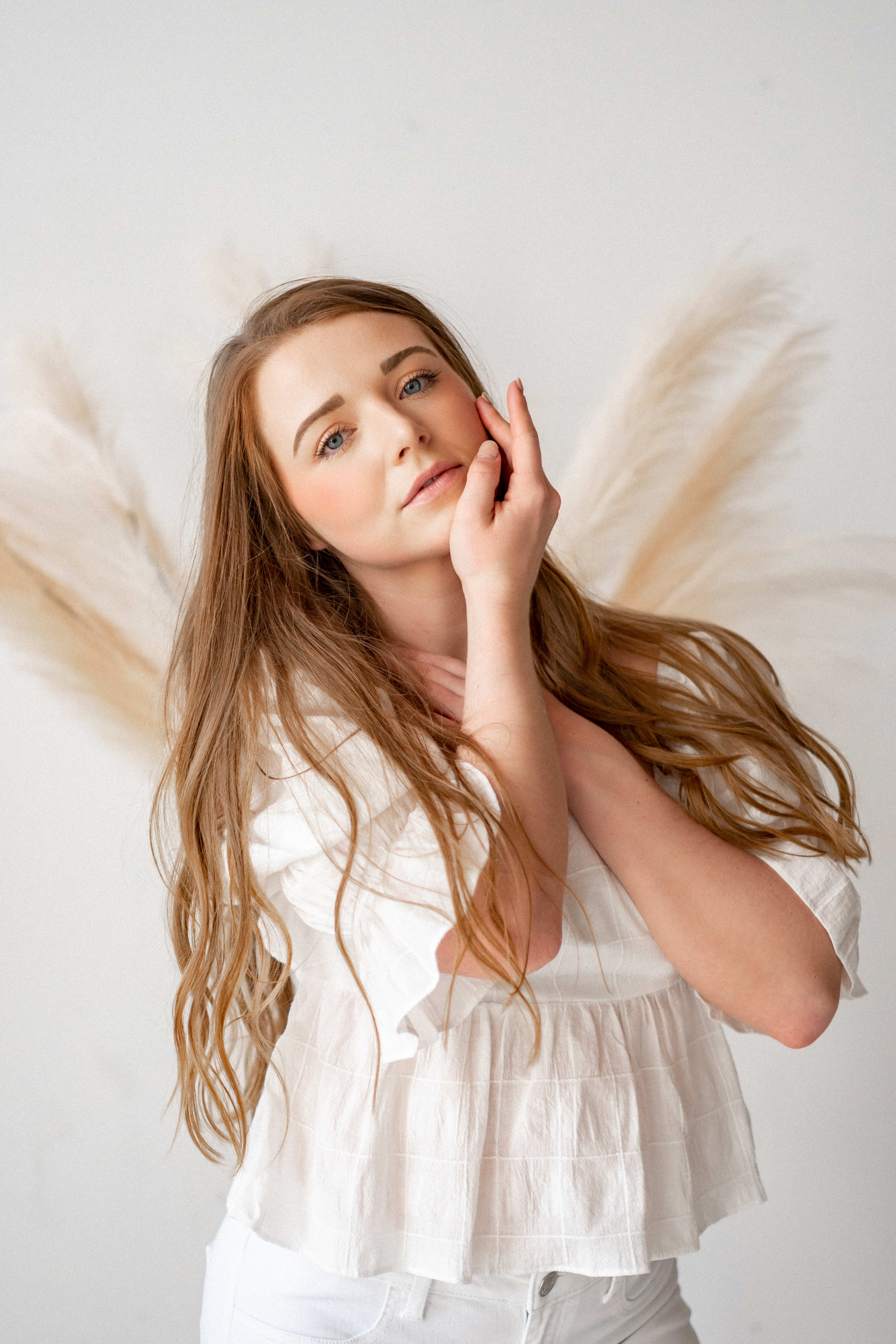 A woman with long hair posing for a minimal boho portrait head shot.