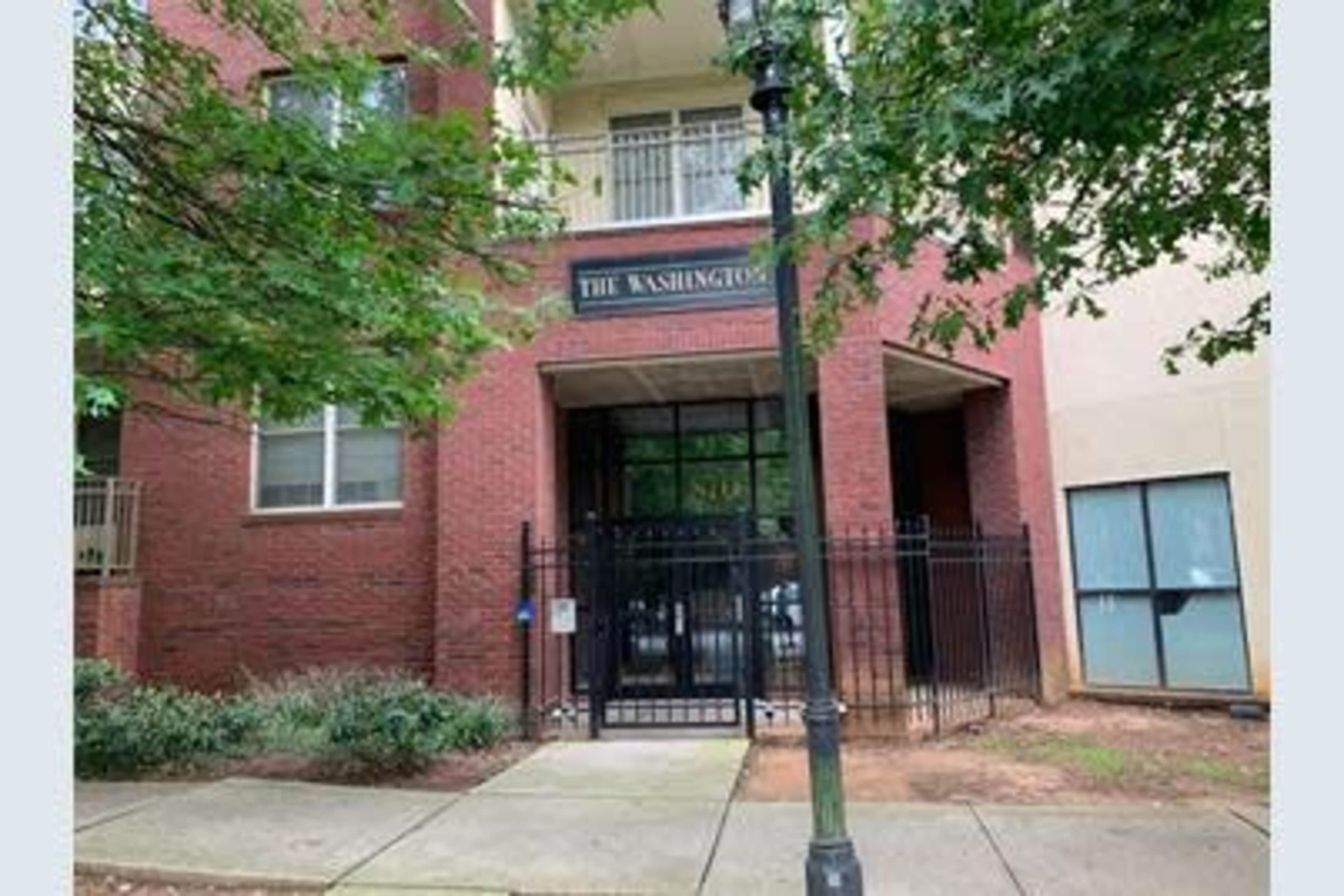 The entrance of a red brick building features a gated area labeled "The Washington."