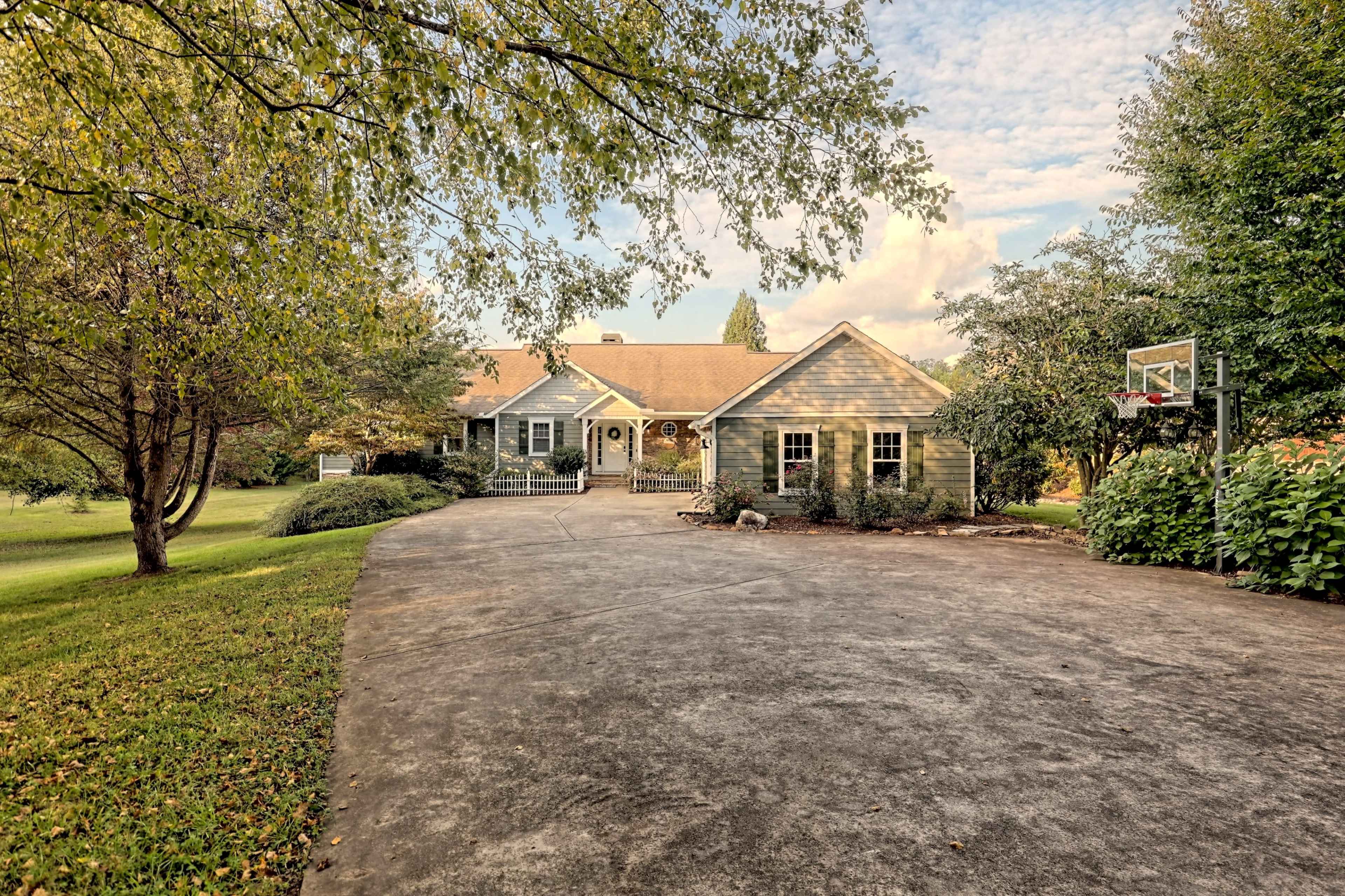 A single-story house with a landscaped front yard and a basketball hoop on the driveway.