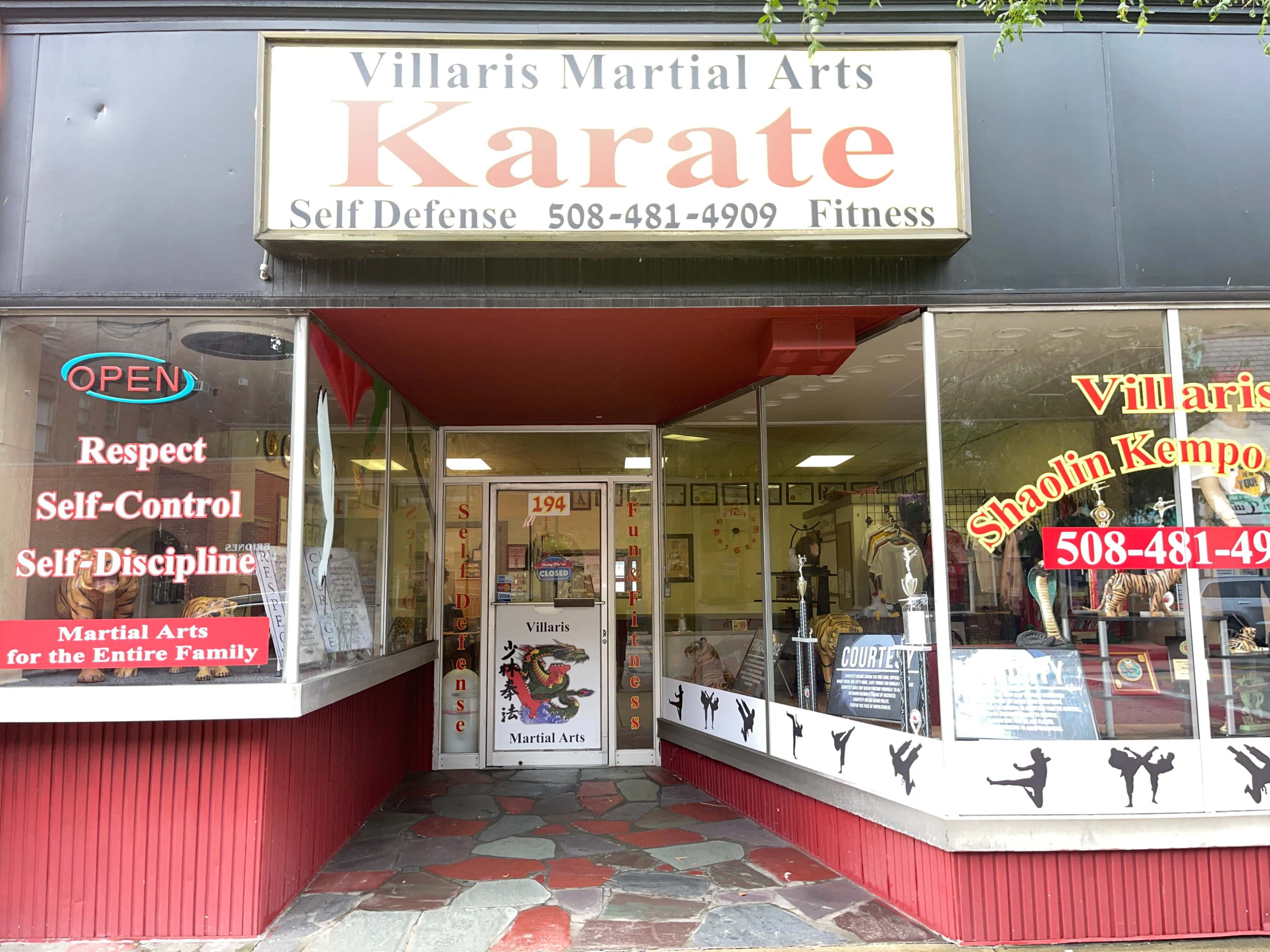The storefront of Villaris Martial Arts, featuring a large sign that reads "Karate" and displays various martial arts-related themes.