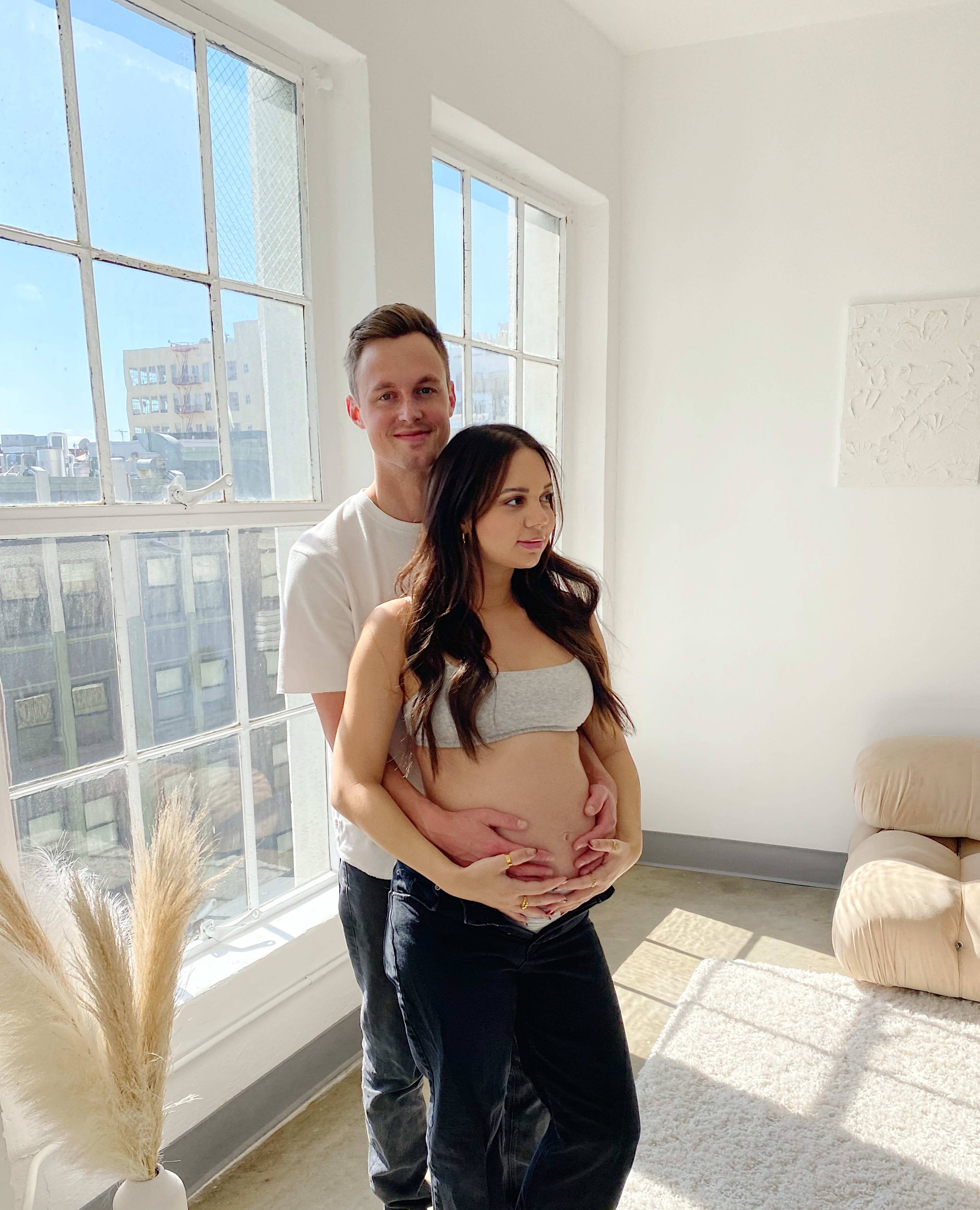 A couple posing for a boho maternity photo shoot.