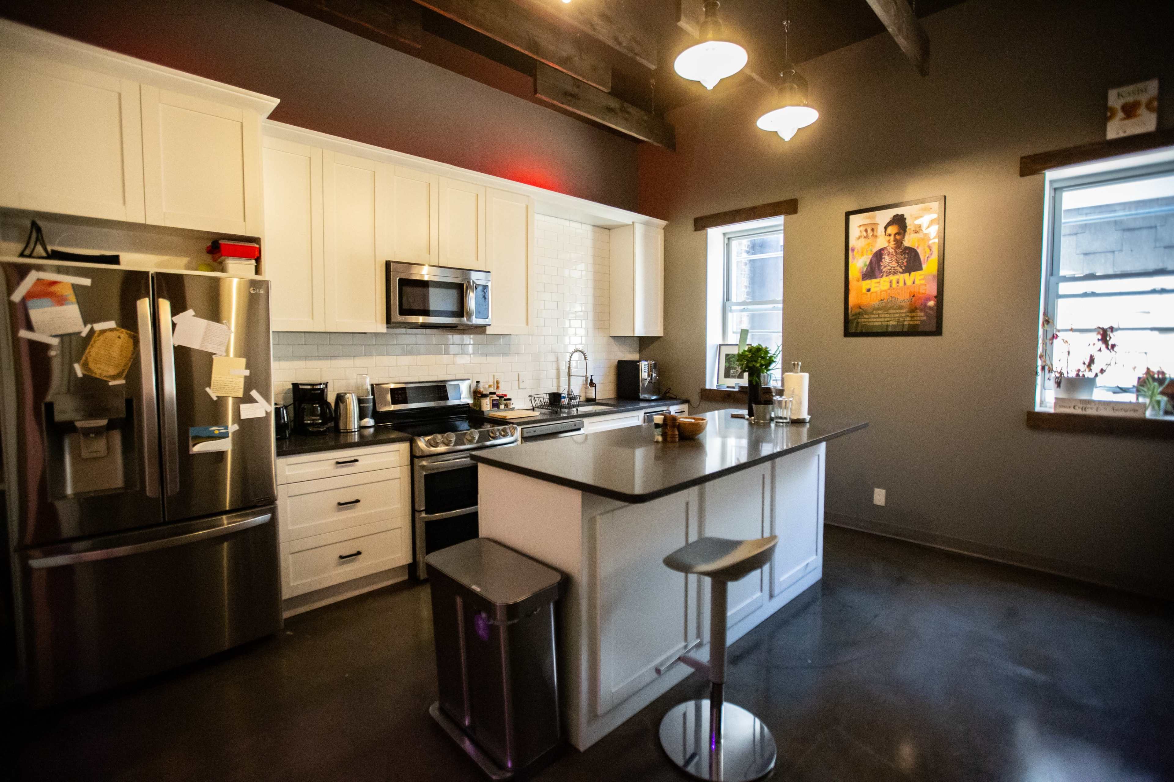 A modern kitchen featuring stainless steel appliances, white cabinetry, and a large island with seating.