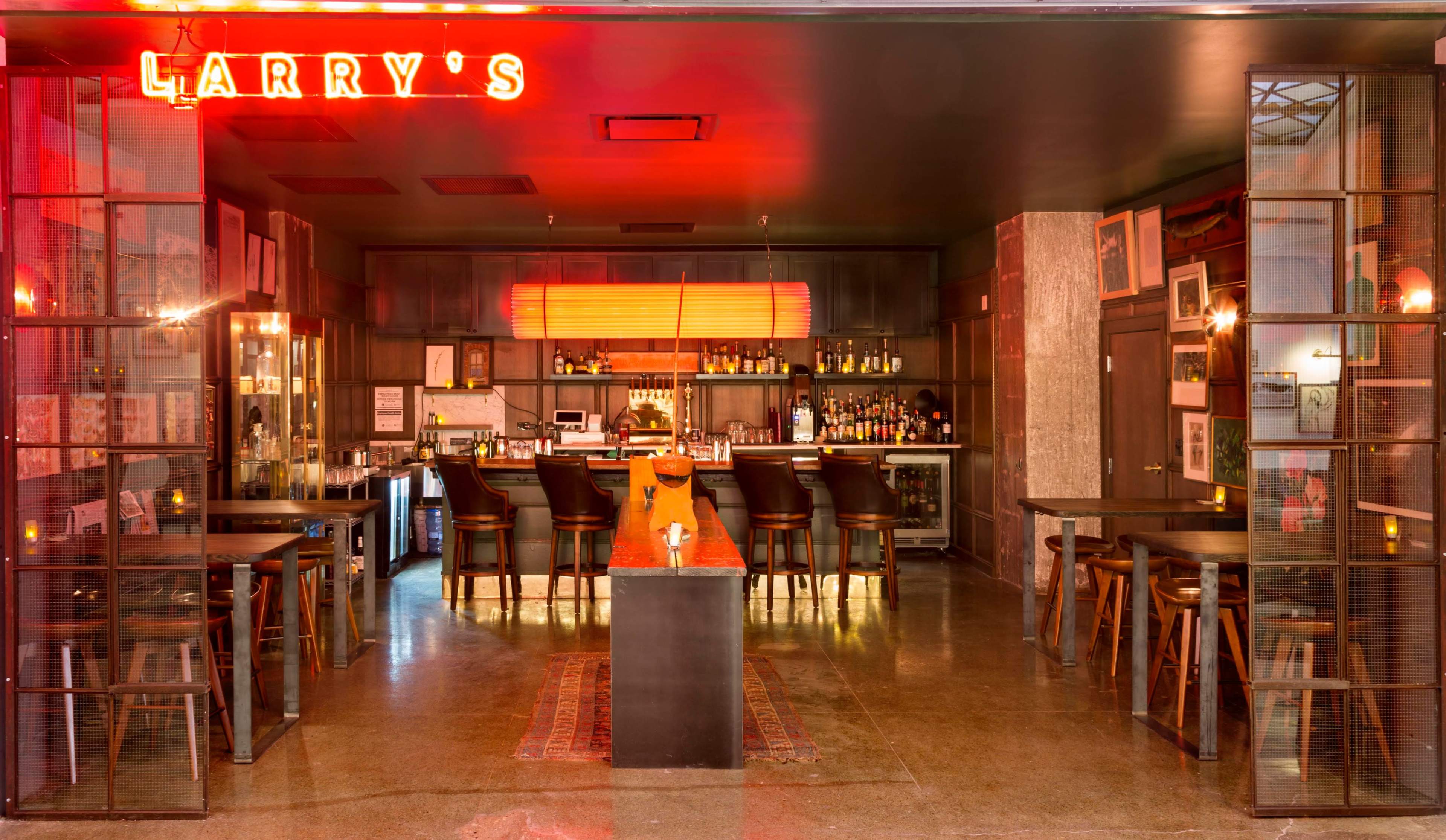 The image shows the interior of a bar named "Larry's," featuring a well-stocked bar counter, high stools, and a warm, illuminated ambiance.