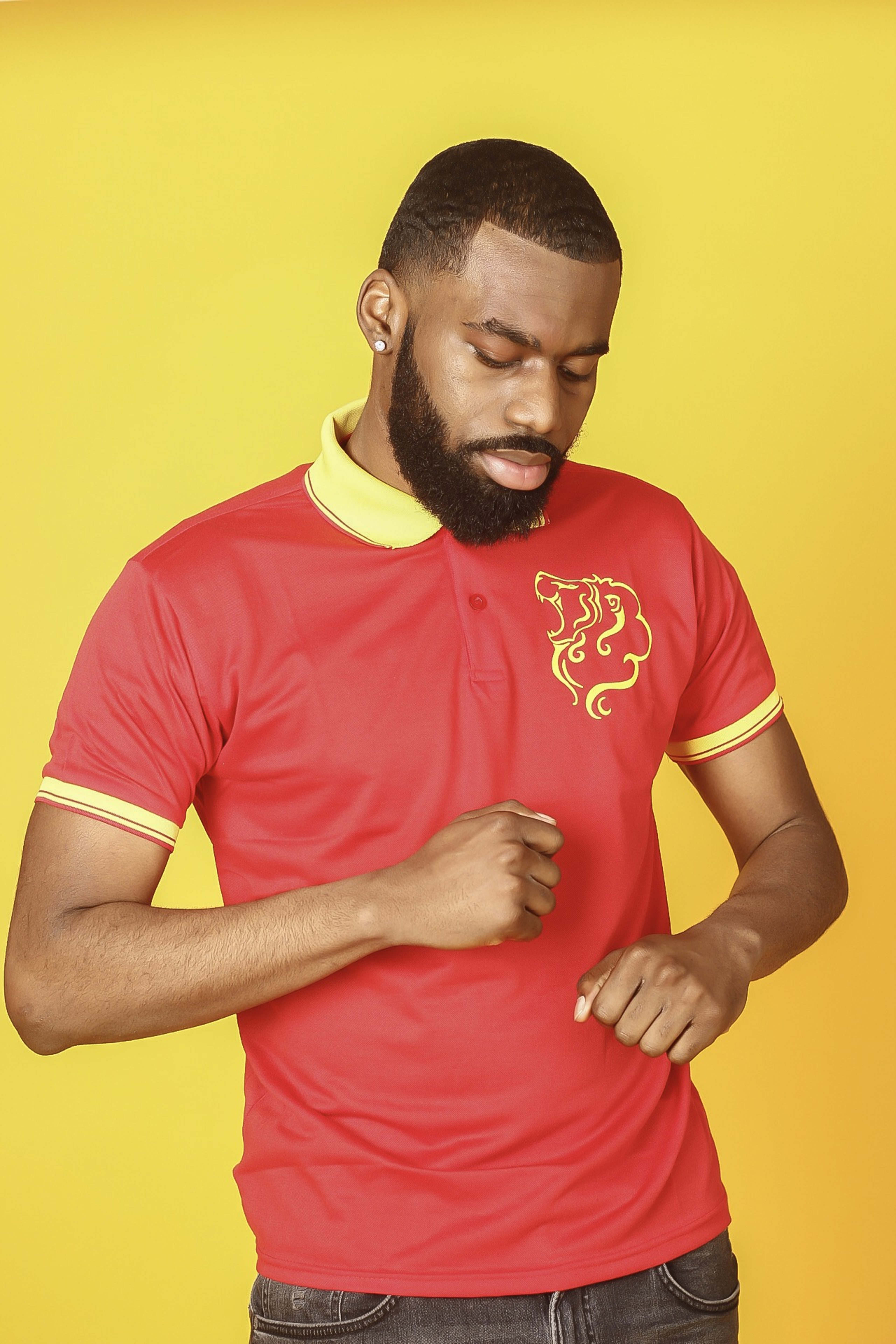 Un hombre con barba modelando moda roja para una sesión de fotos.