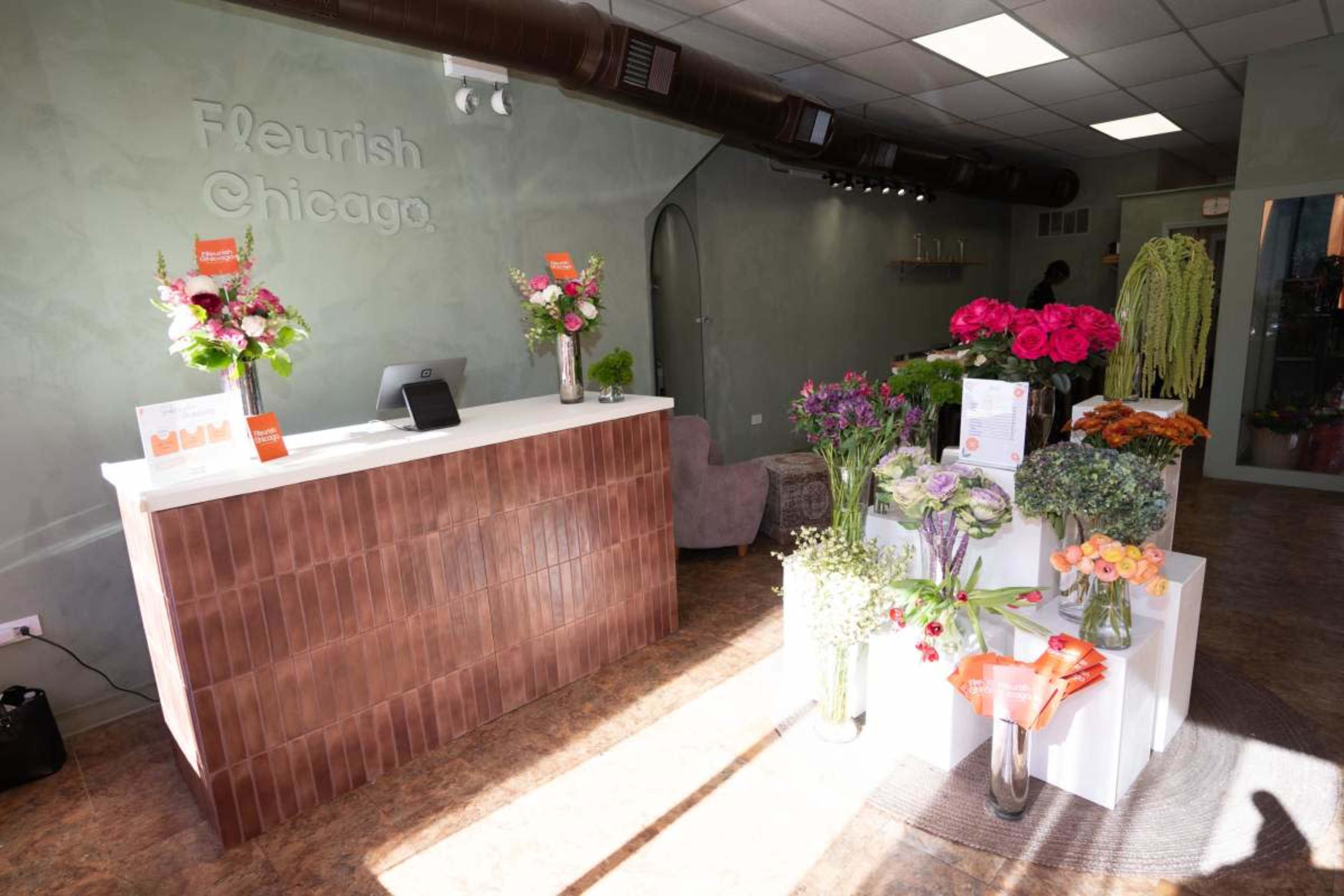 The image shows the interior of a flower shop named "Fleurish Chicago," featuring a reception counter and displays of various fresh flowers.