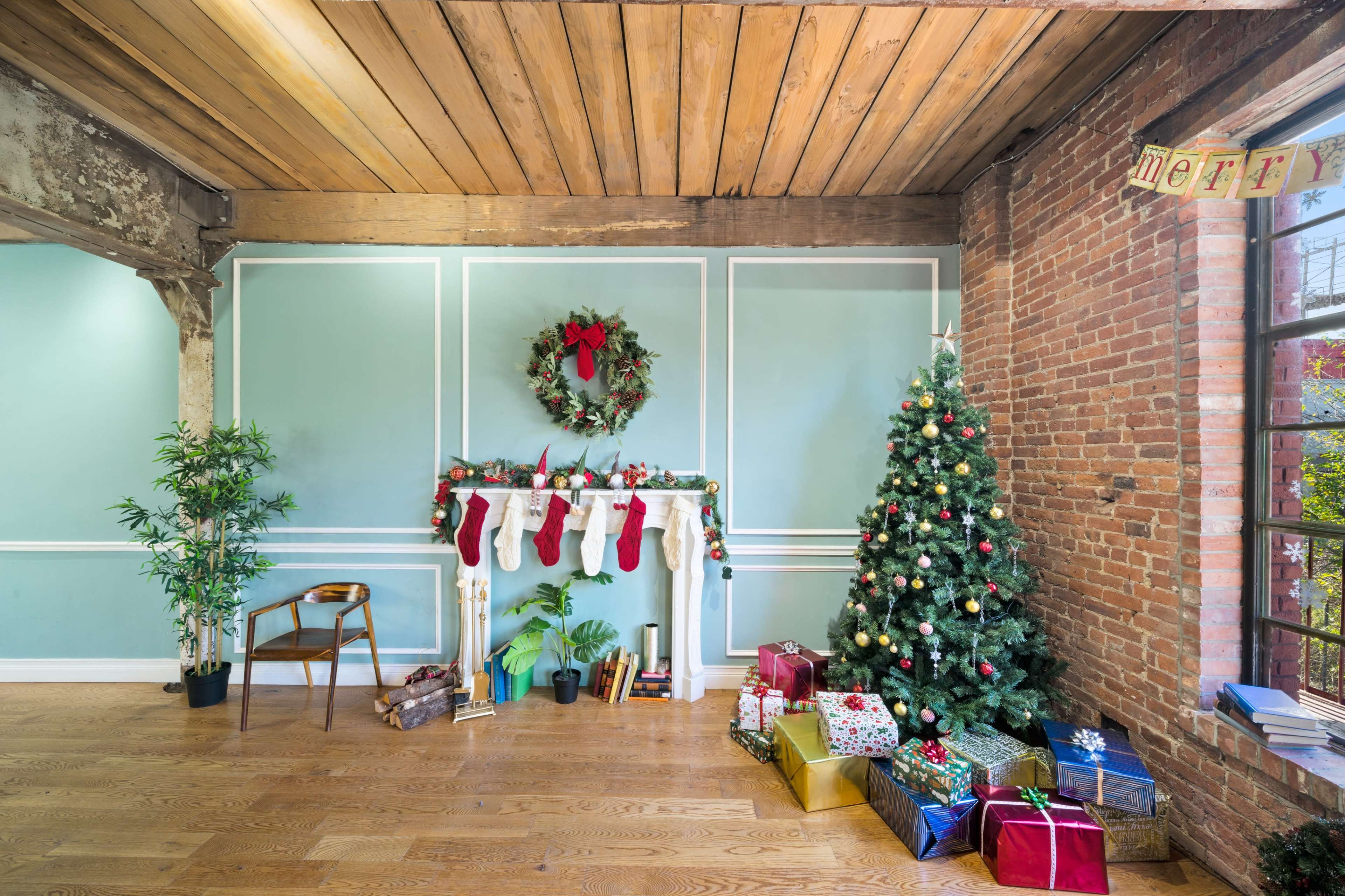 The image shows a decorated room with a Christmas tree, stockings hanging over a mantel, and presents arranged on the floor.