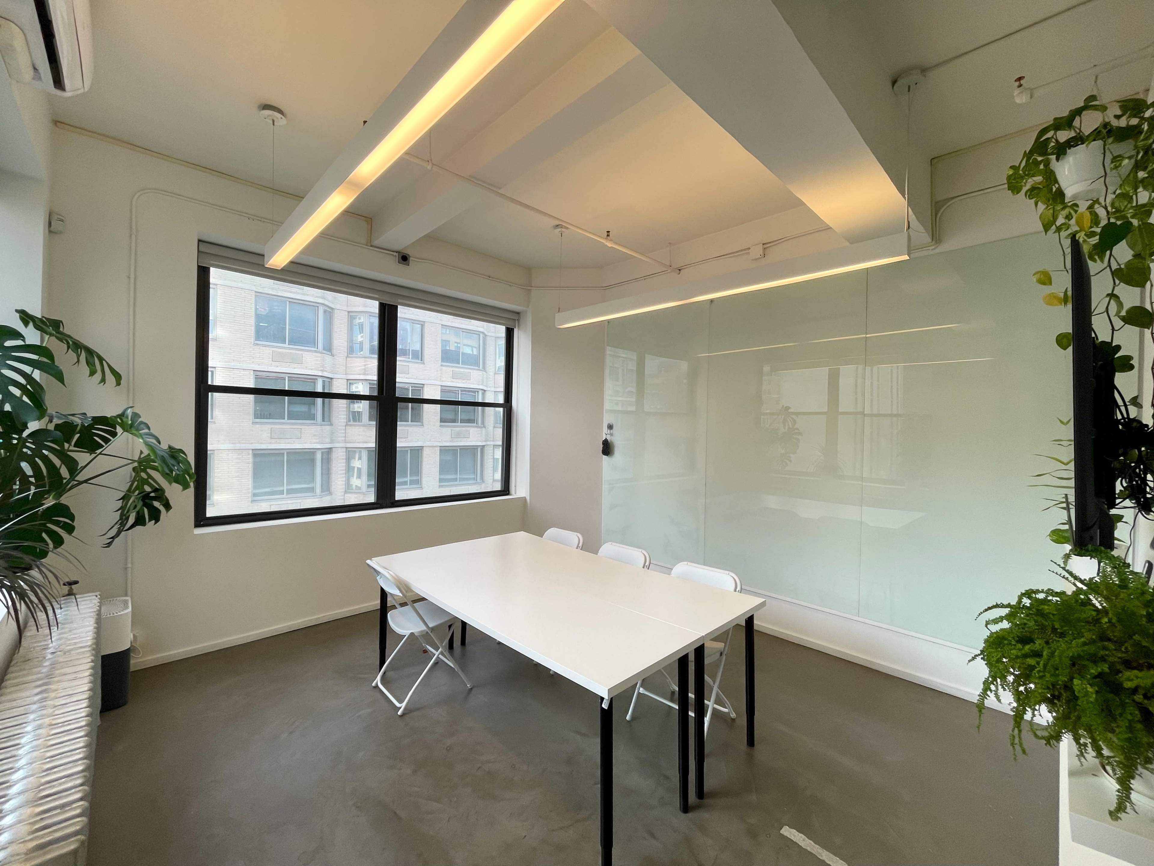 Light filled large meeting room with floor-to-ceiling white boards Image in Midtown Manhattan, New York, NY
