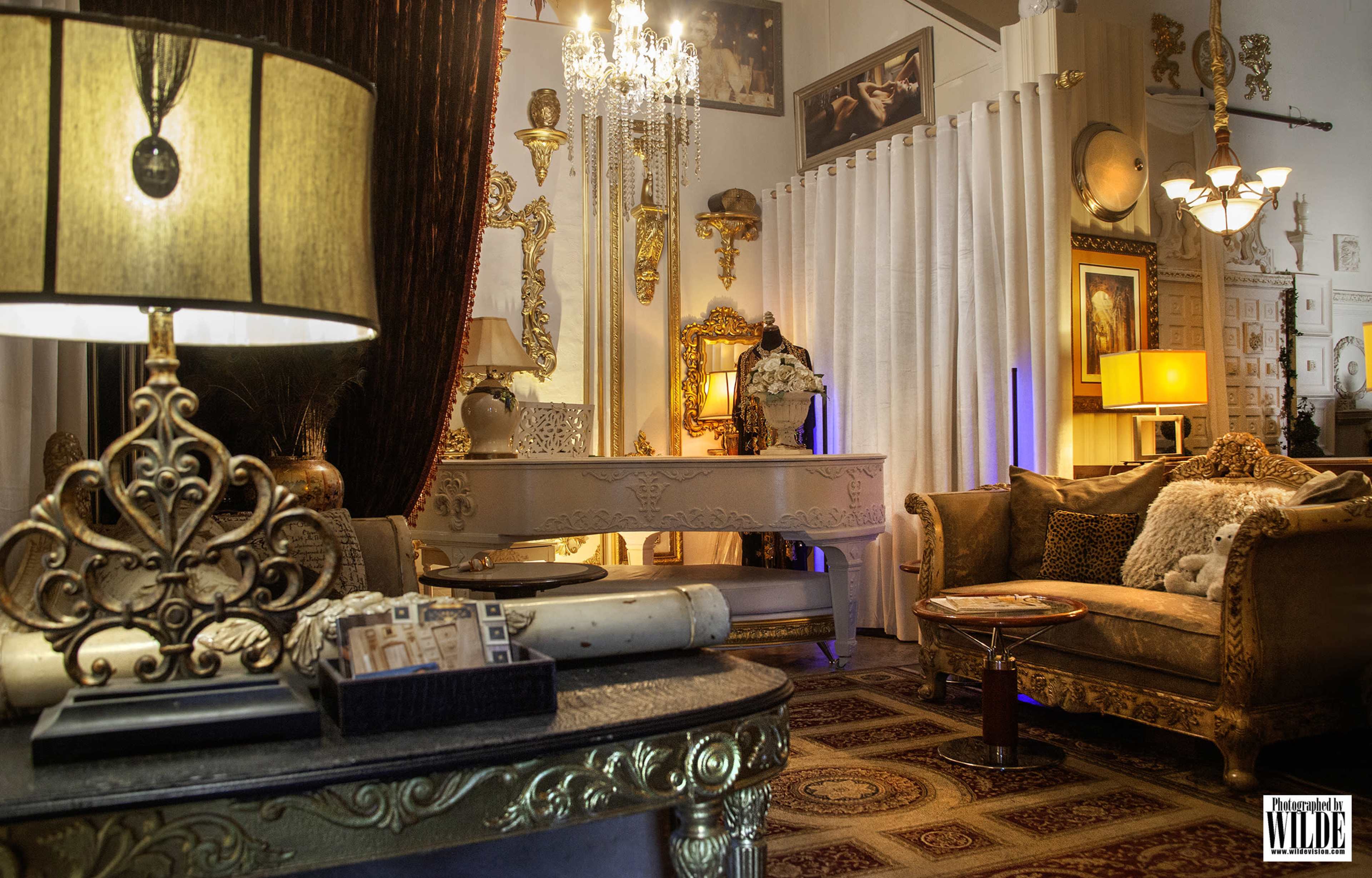 The image depicts a lavishly decorated room with ornate furnishings, a chandelier, and elegant lighting.