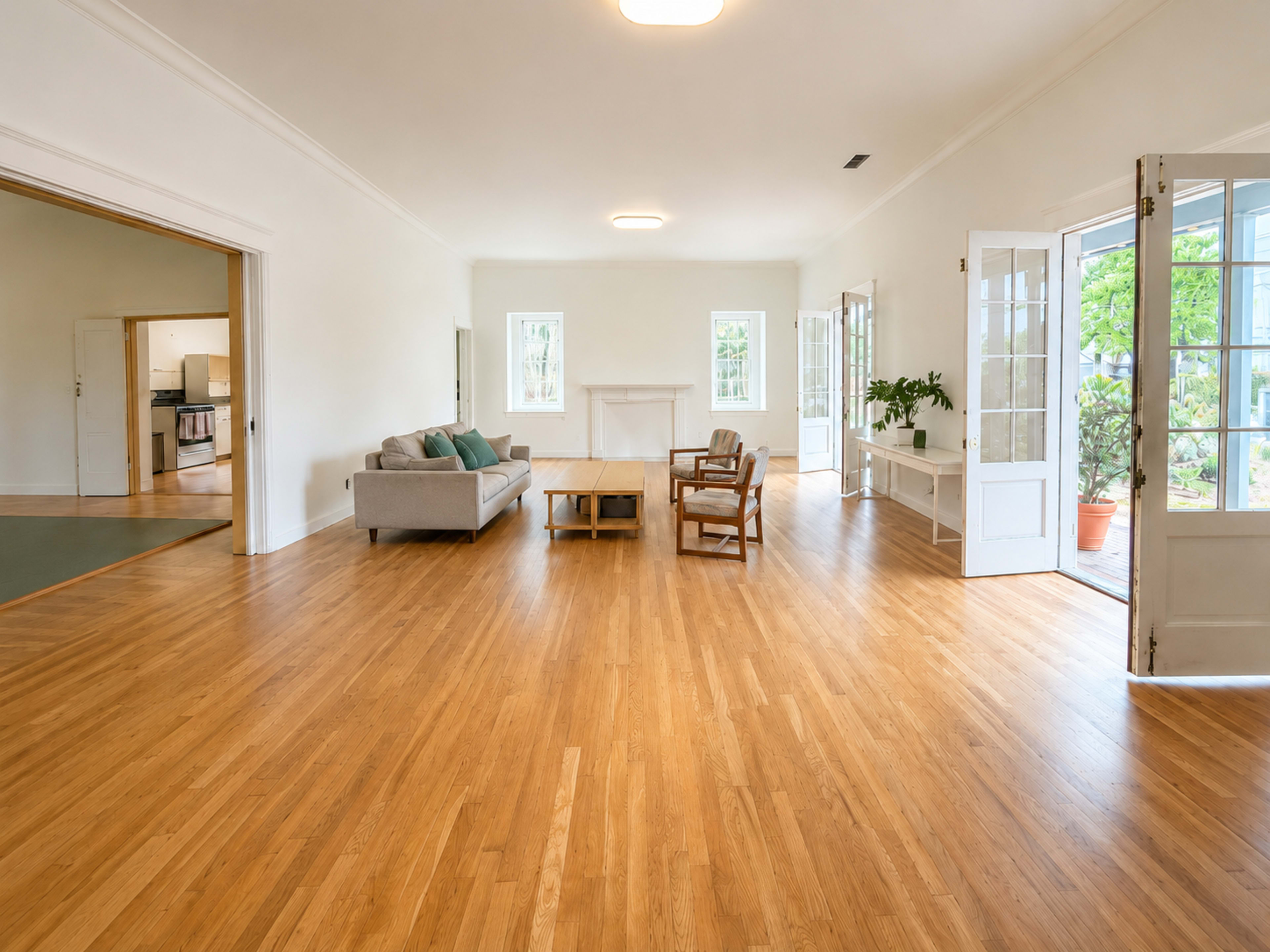 The image shows a bright, spacious living room with hardwood floors, large windows, and a mix of modern and classic furniture.