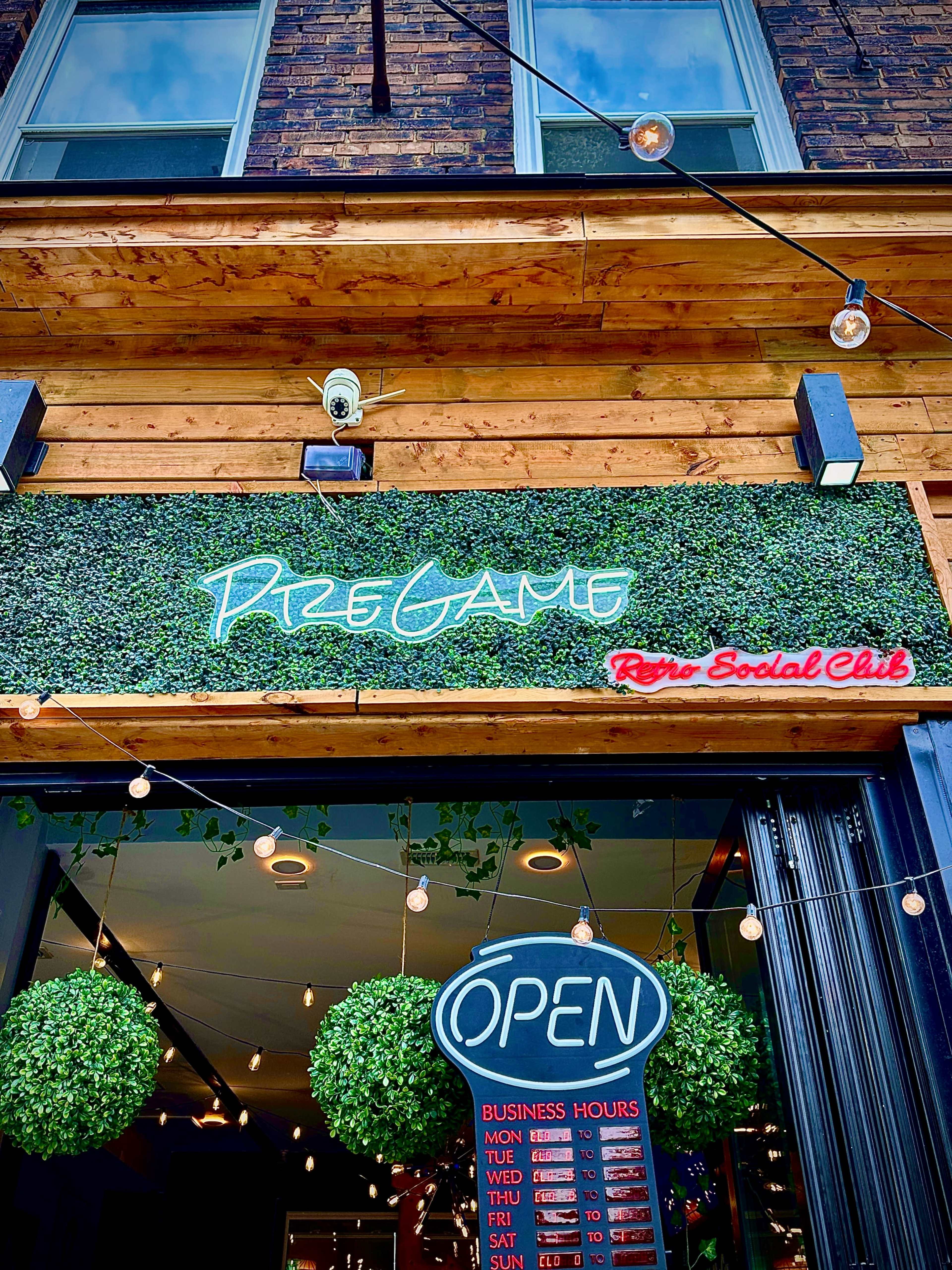 The entrance to a venue called "Pine Game Retro Social Club" features a green foliage sign and an open sign with business hours displayed.