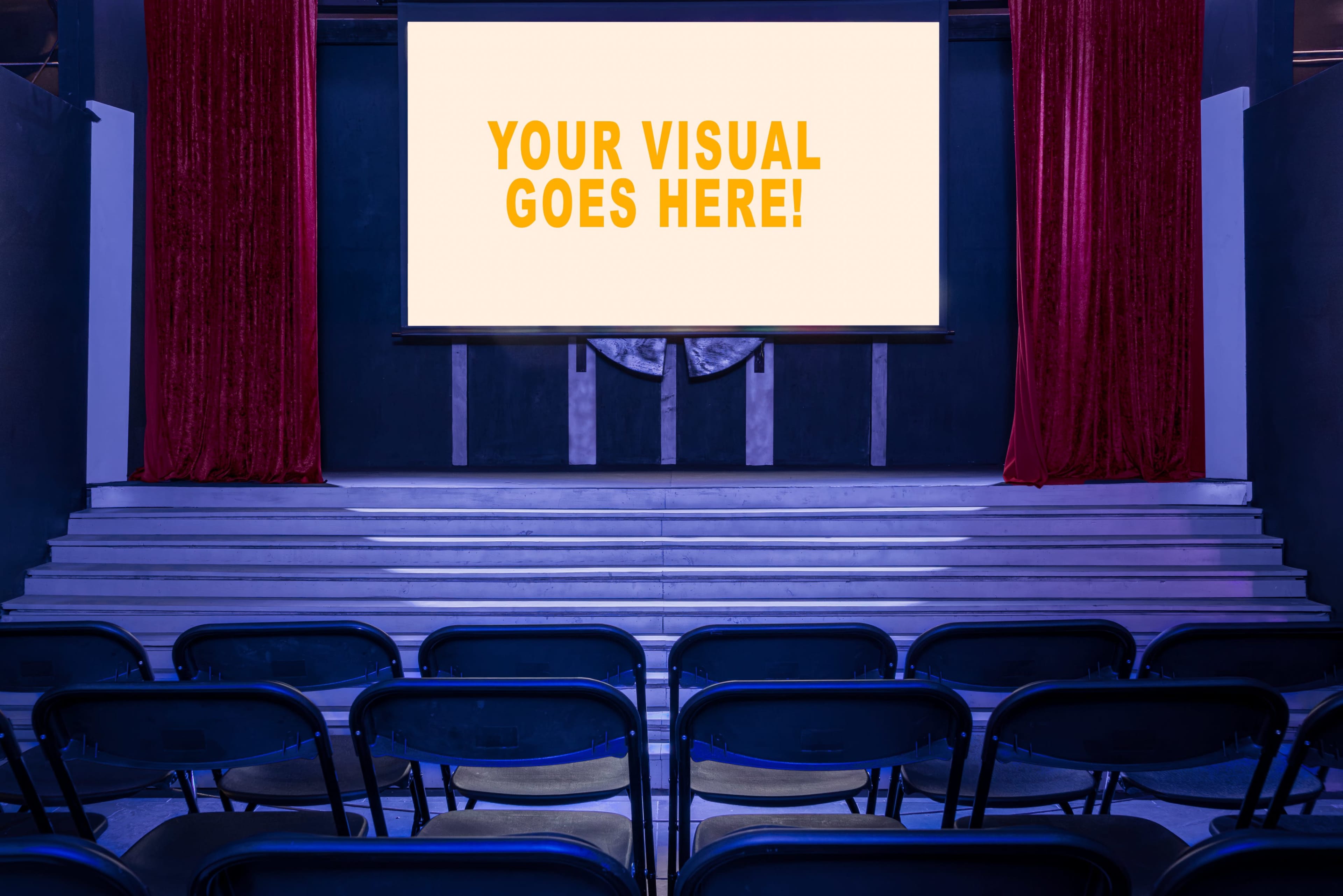 An empty auditorium features a large screen with a message in bold text, flanked by red curtains and arranged seating.