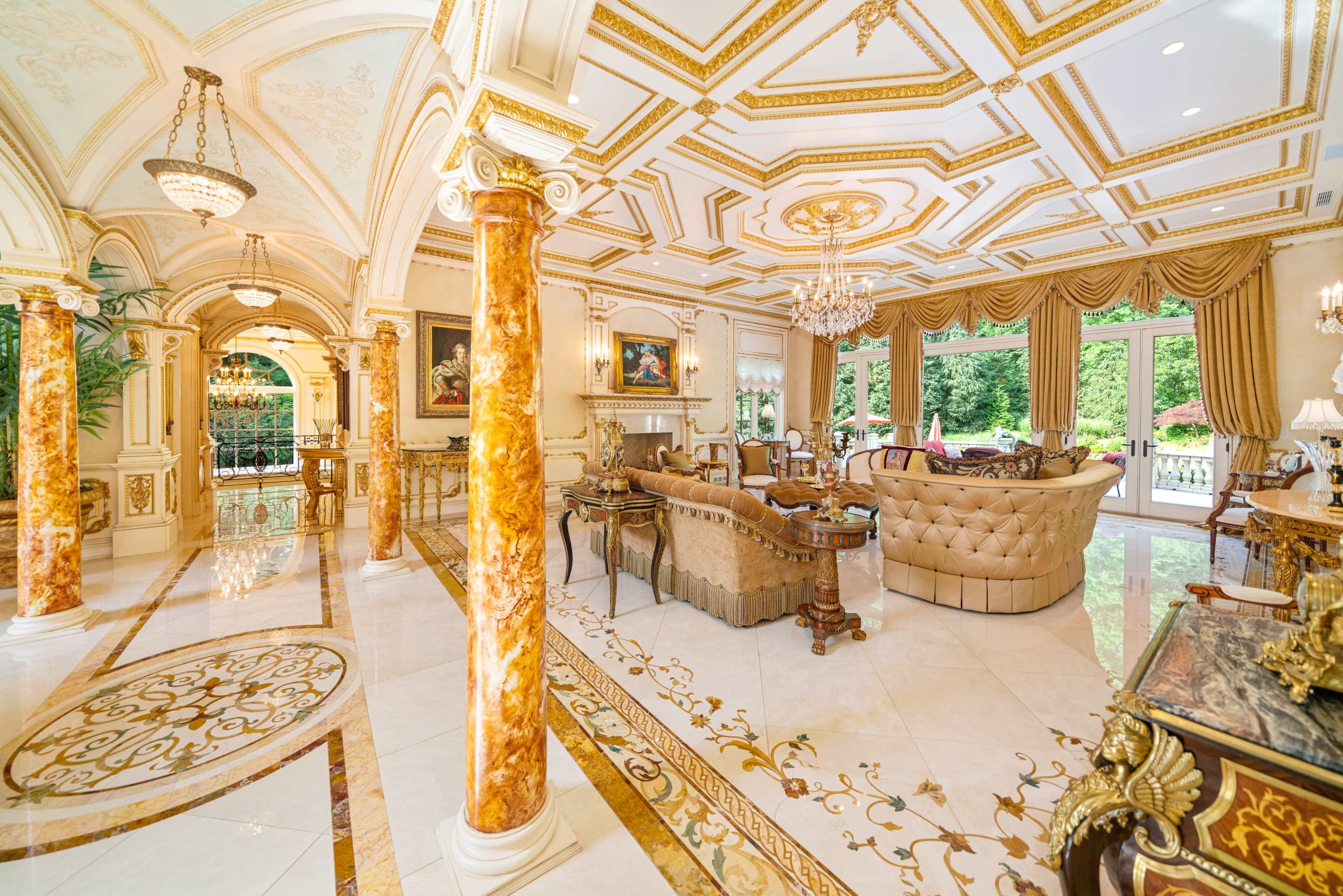 An opulent interior of a grand living space featuring ornate columns, elegant furniture, and elaborate ceiling designs.