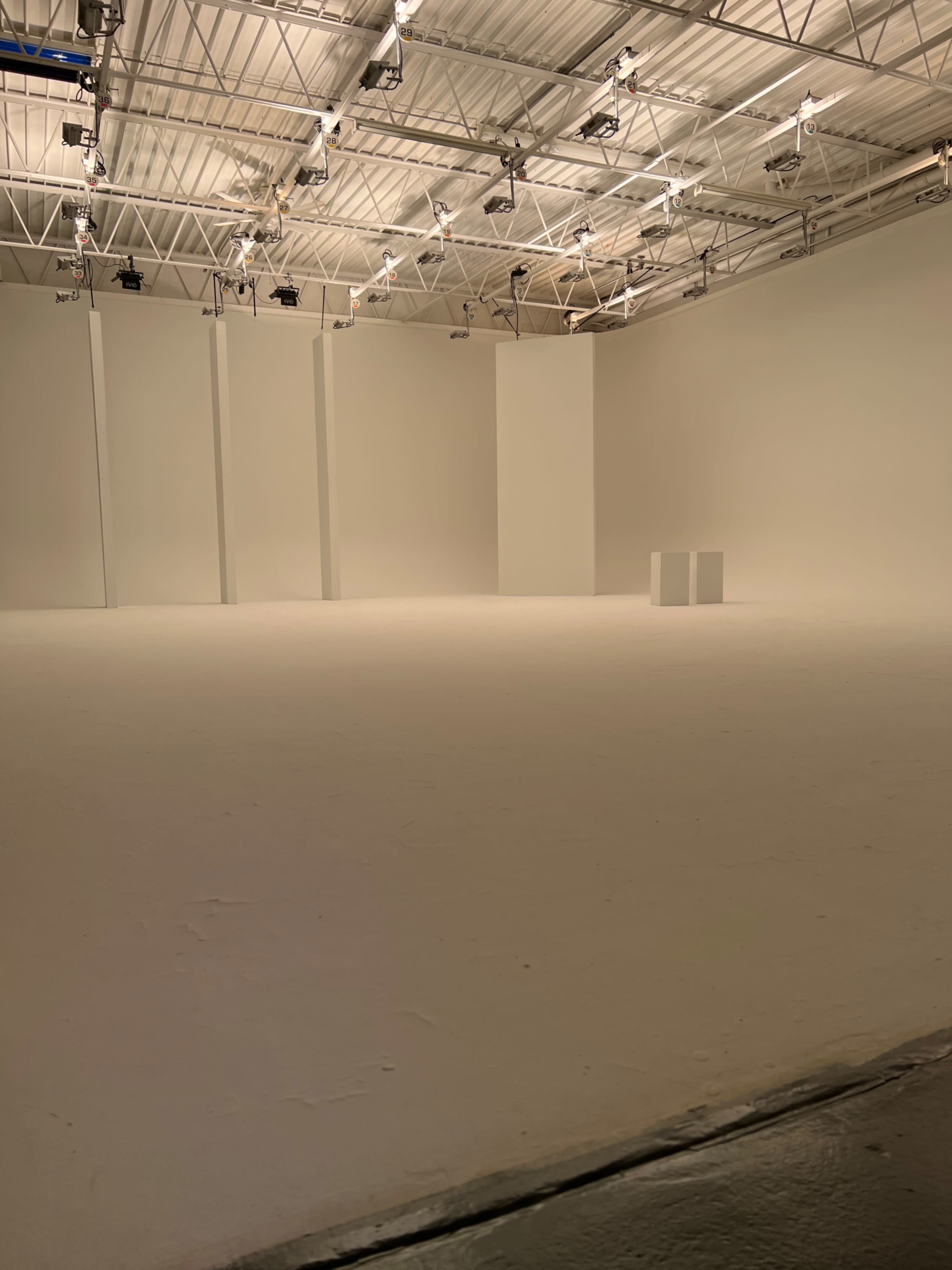 An empty, spacious gallery with white walls and a plain white floor.