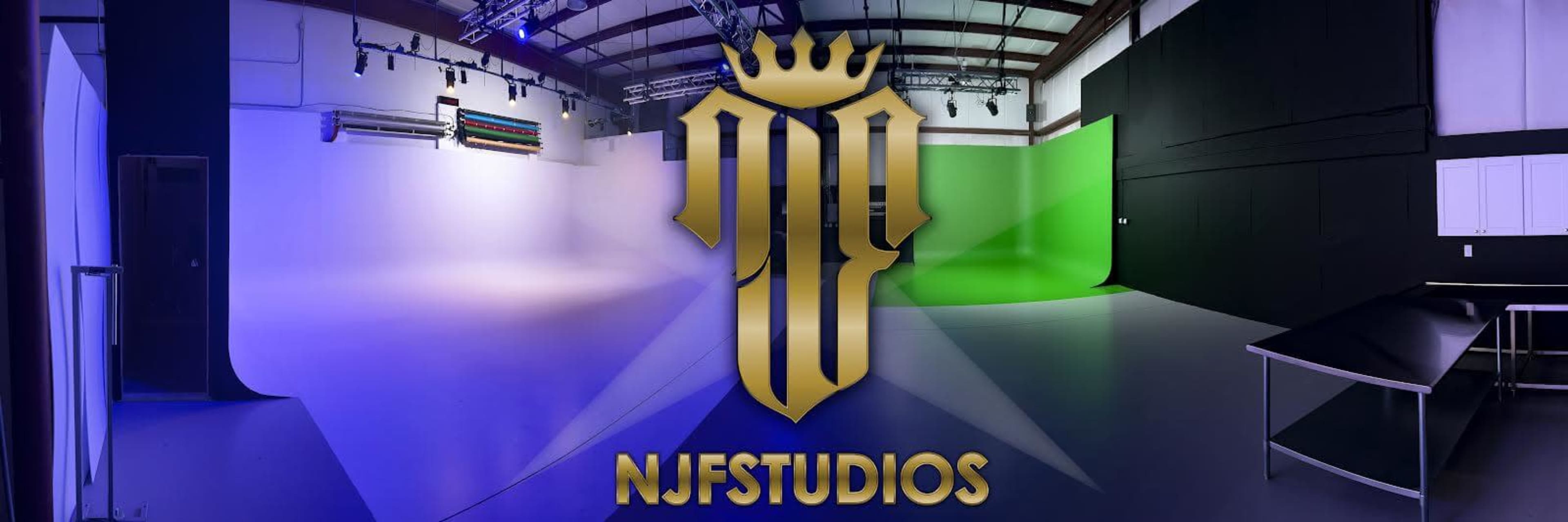 The image shows a photography studio with curved backdrops in blue and green, illuminated by soft lighting.