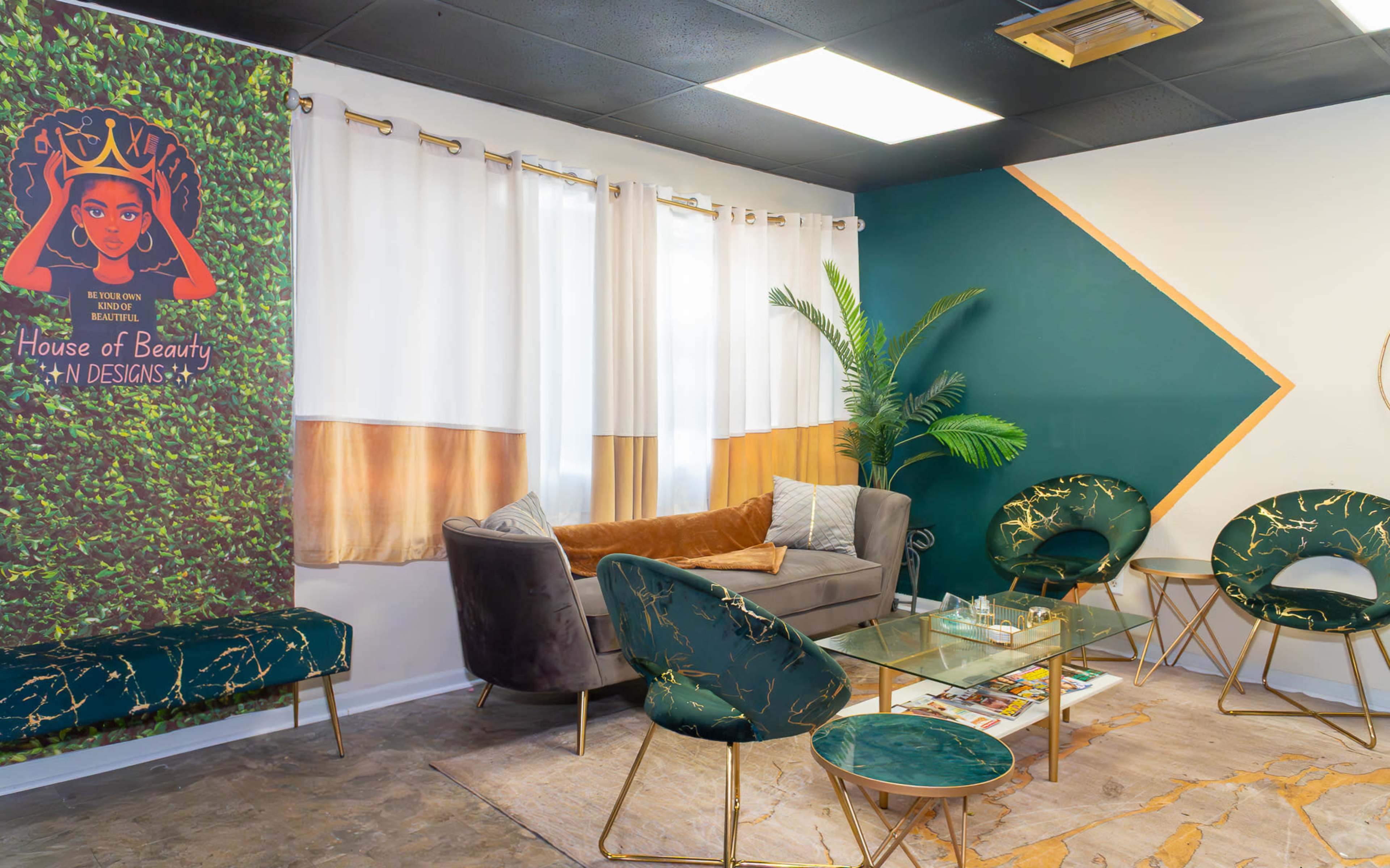 The image shows a modern beauty salon interior featuring a cozy seating area with green and gold accents, a decorative banner, and a mix of plants and stylish furniture.