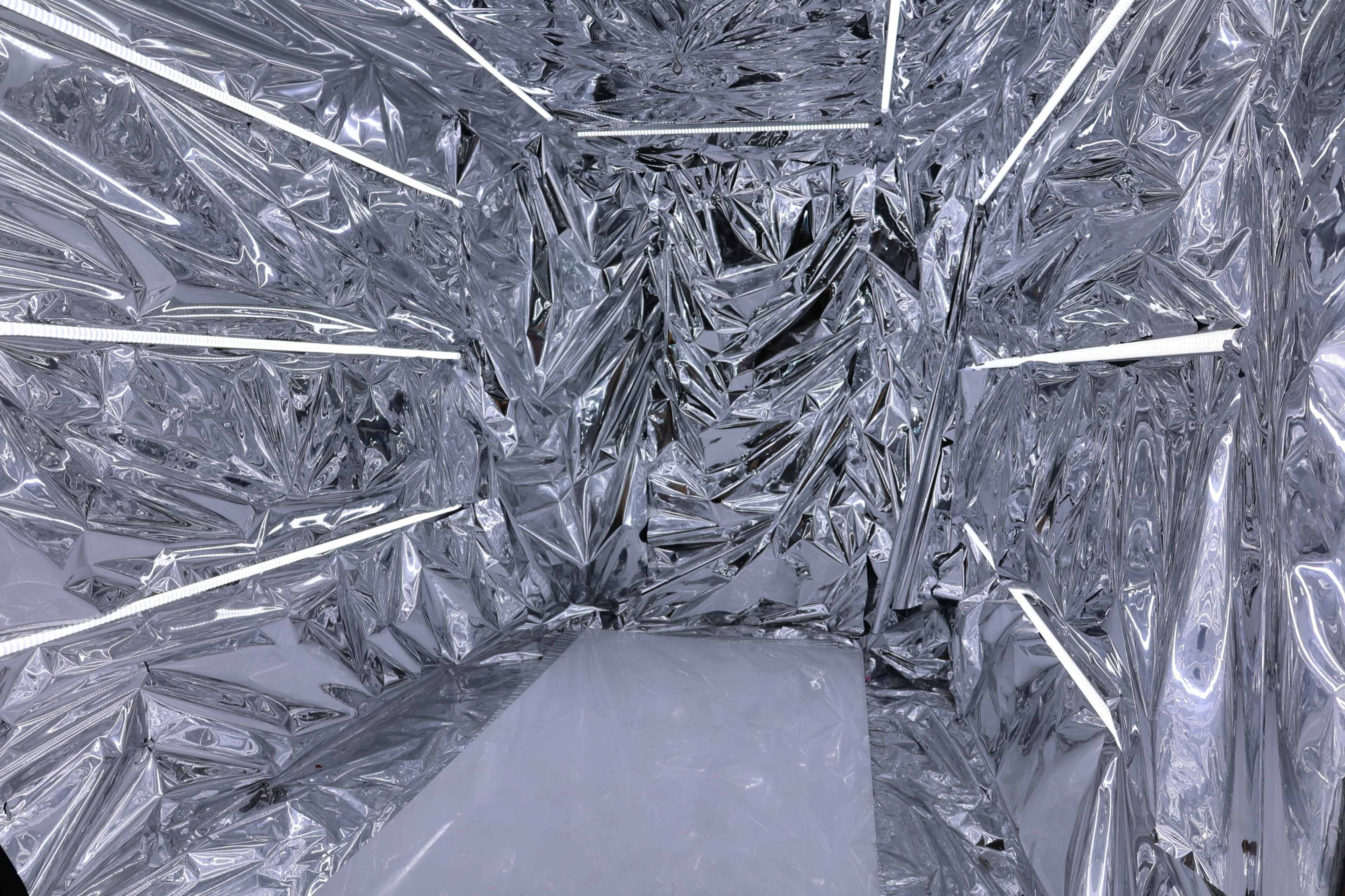 A room with reflective, crinkled silver surfaces covering the walls, ceiling, and floor.
