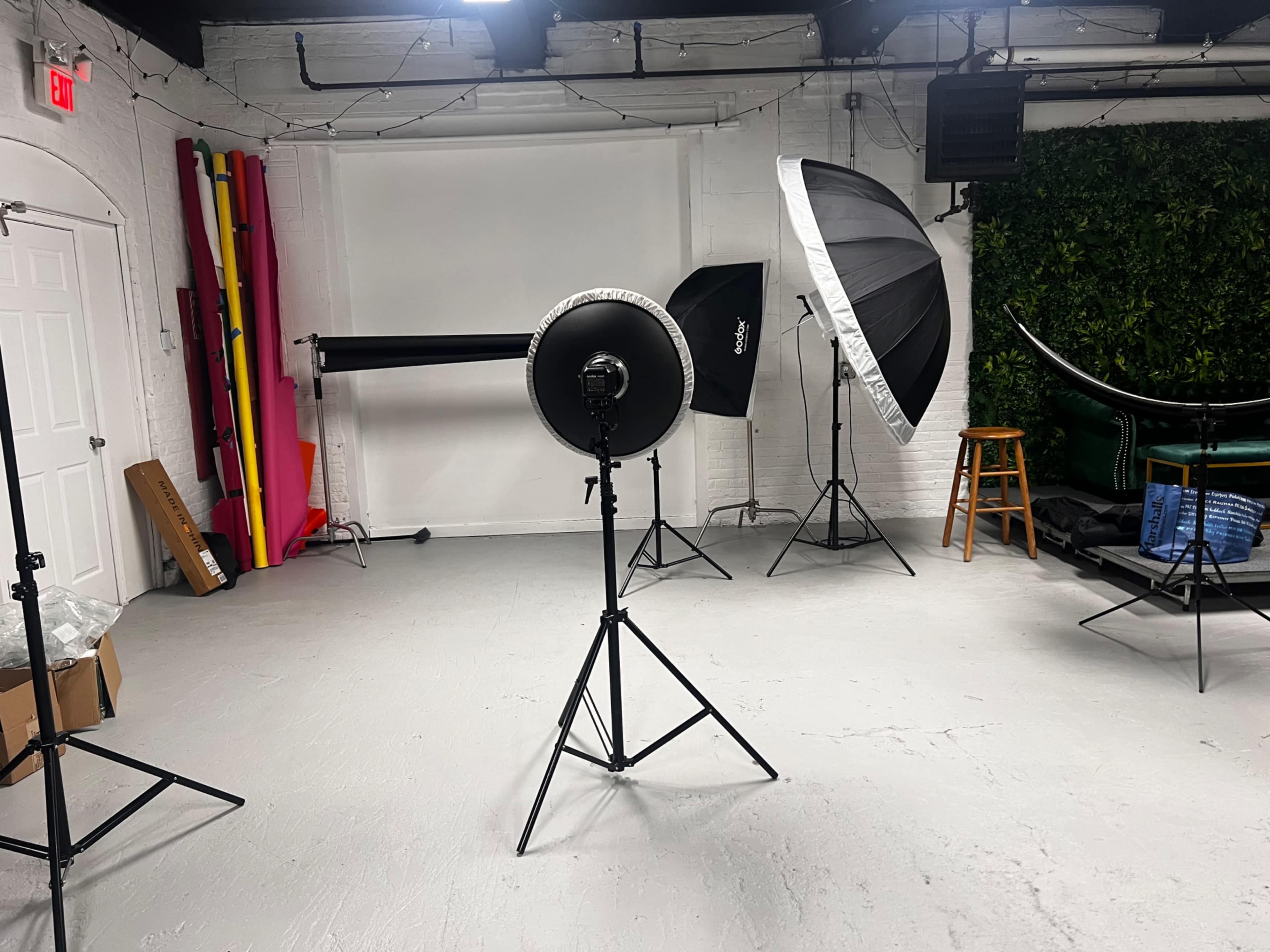 A photography studio setup with various lighting equipment and backdrops arranged in the space.