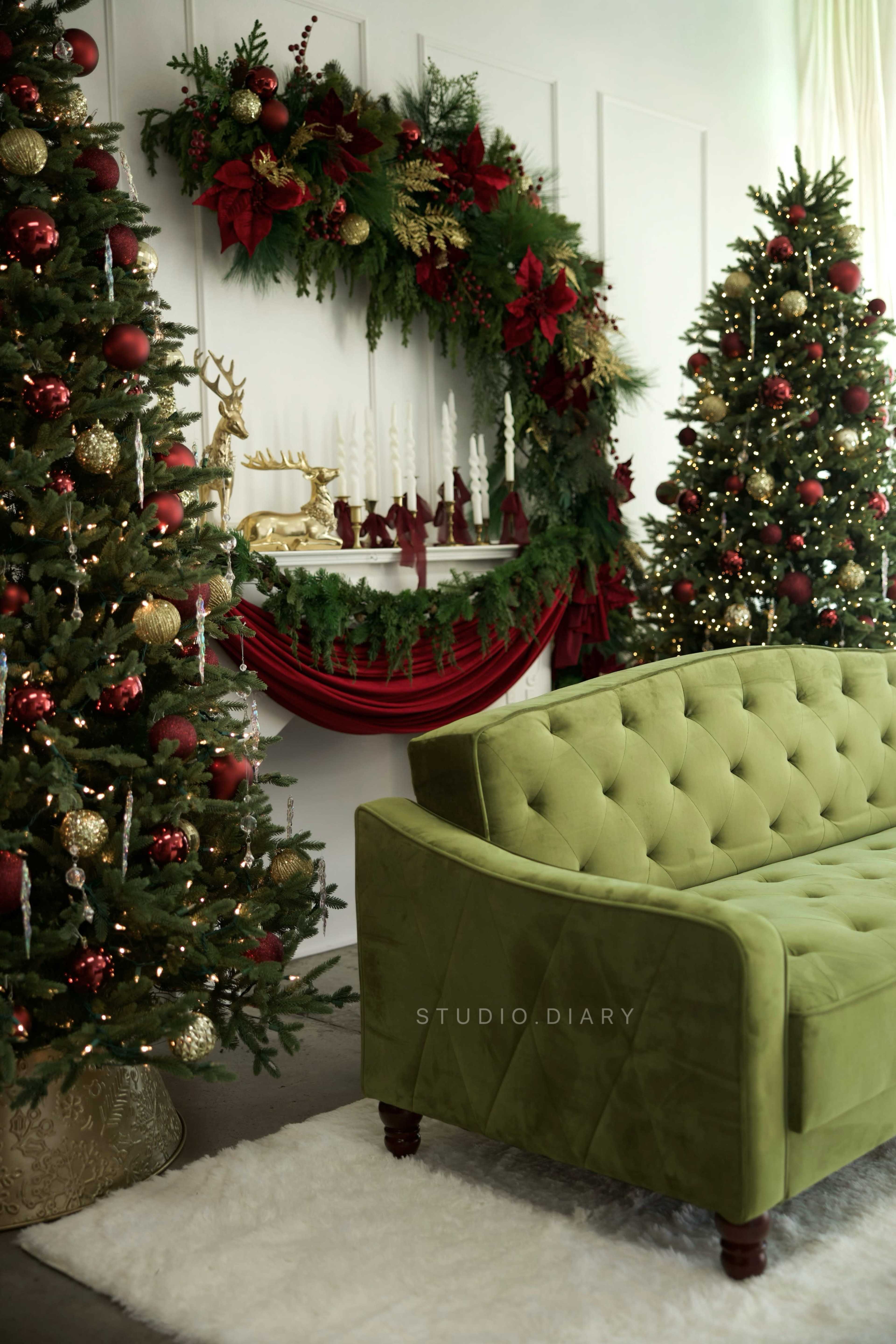 The image features a cozy living room decorated for the holidays, with a green tufted sofa, two Christmas trees adorned with ornaments, and a garland draped over a mantel.