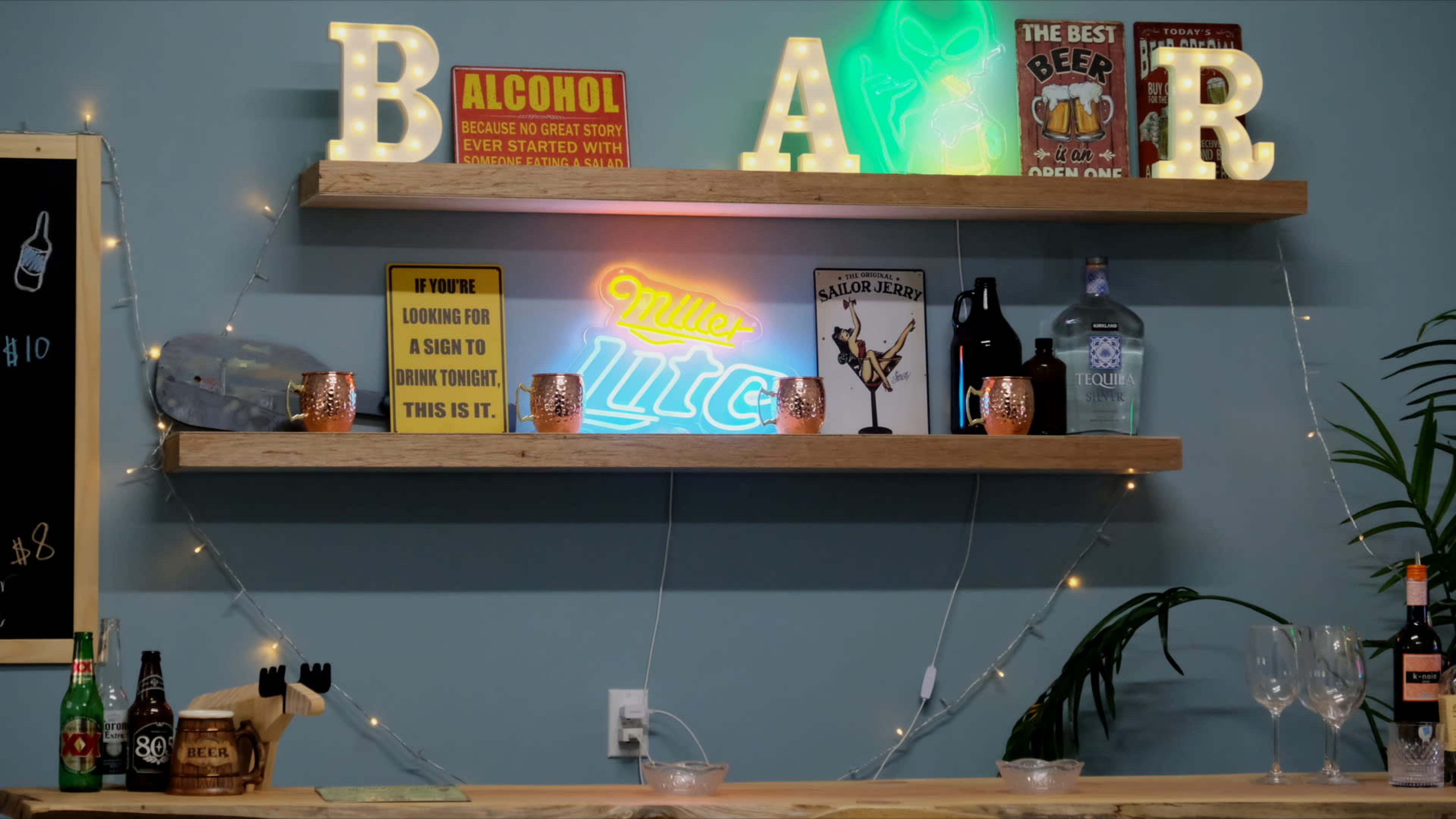 The image shows a bar display with illuminated letters spelling "BAR," shelves holding various beverages, decorative signs, and a neon "Miller Lite" light.