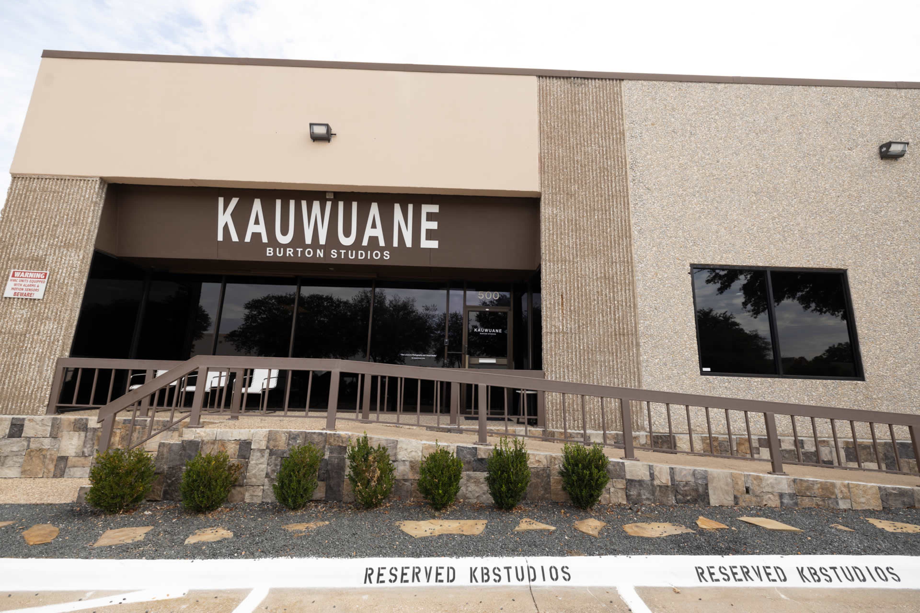 The image shows the exterior of Kauwuane Burton Studios, featuring a modern building facade with a ramp leading to the entrance and a reserved parking area labeled for KB Studios.