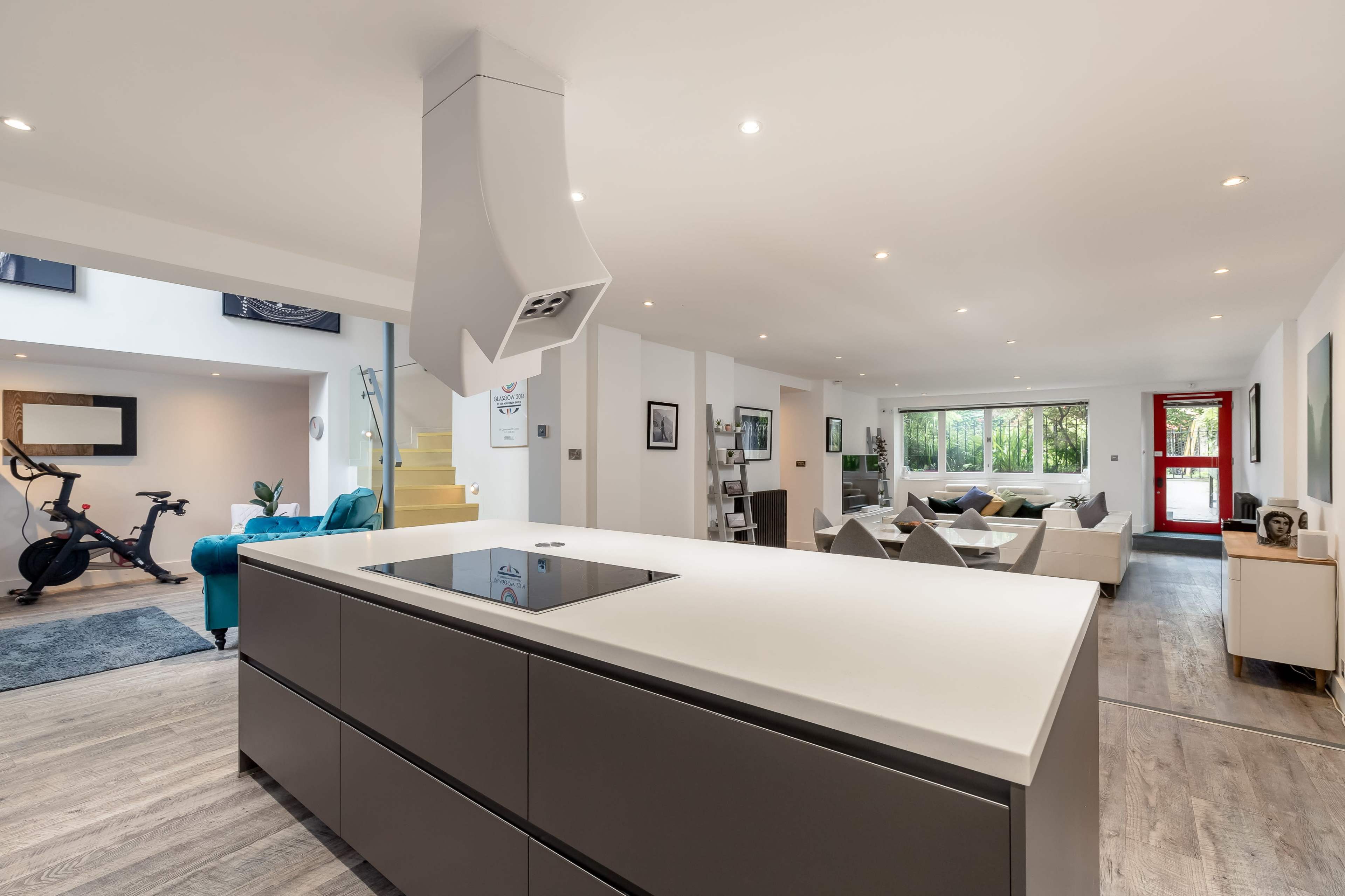 A modern open-concept kitchen and living area with a large kitchen island, sleek appliances, and a spacious seating area.