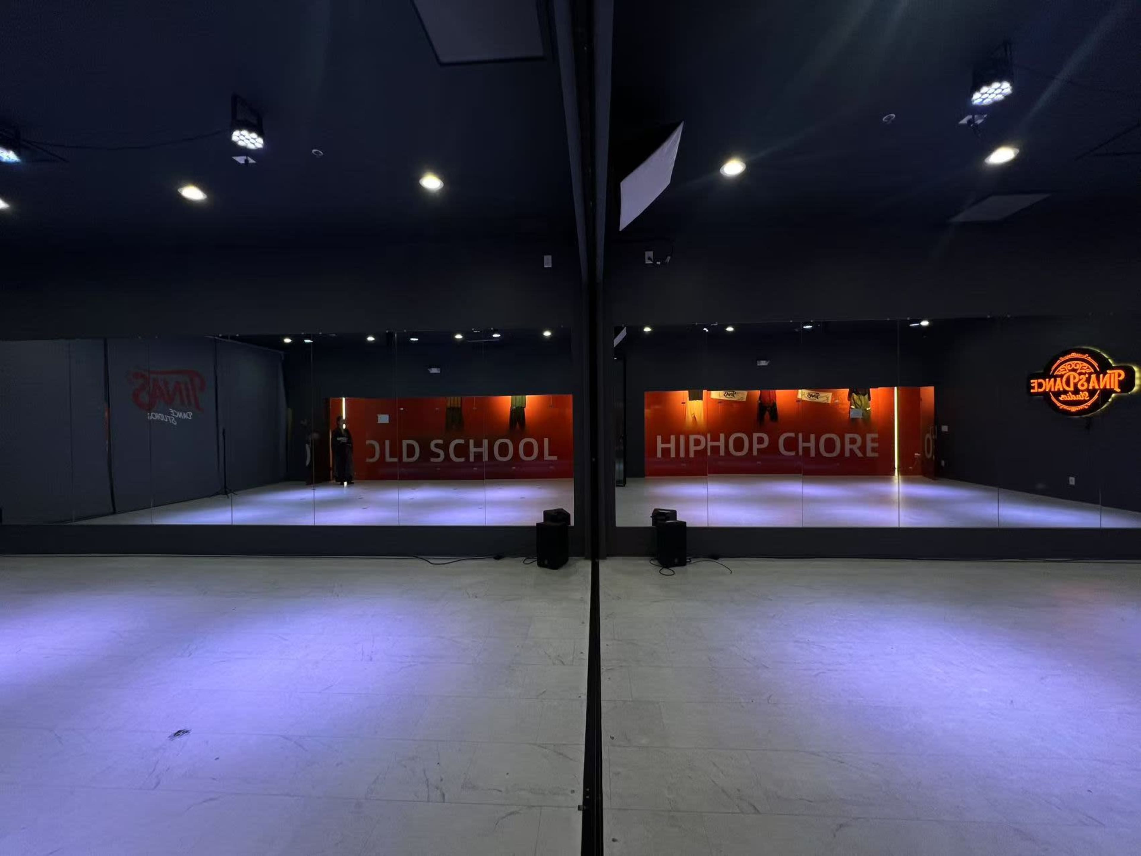 The image shows a dance studio with mirrored walls, featuring the words "OLD SCHOOL" and "HIPHOP CHORE" displayed on the opposite wall.