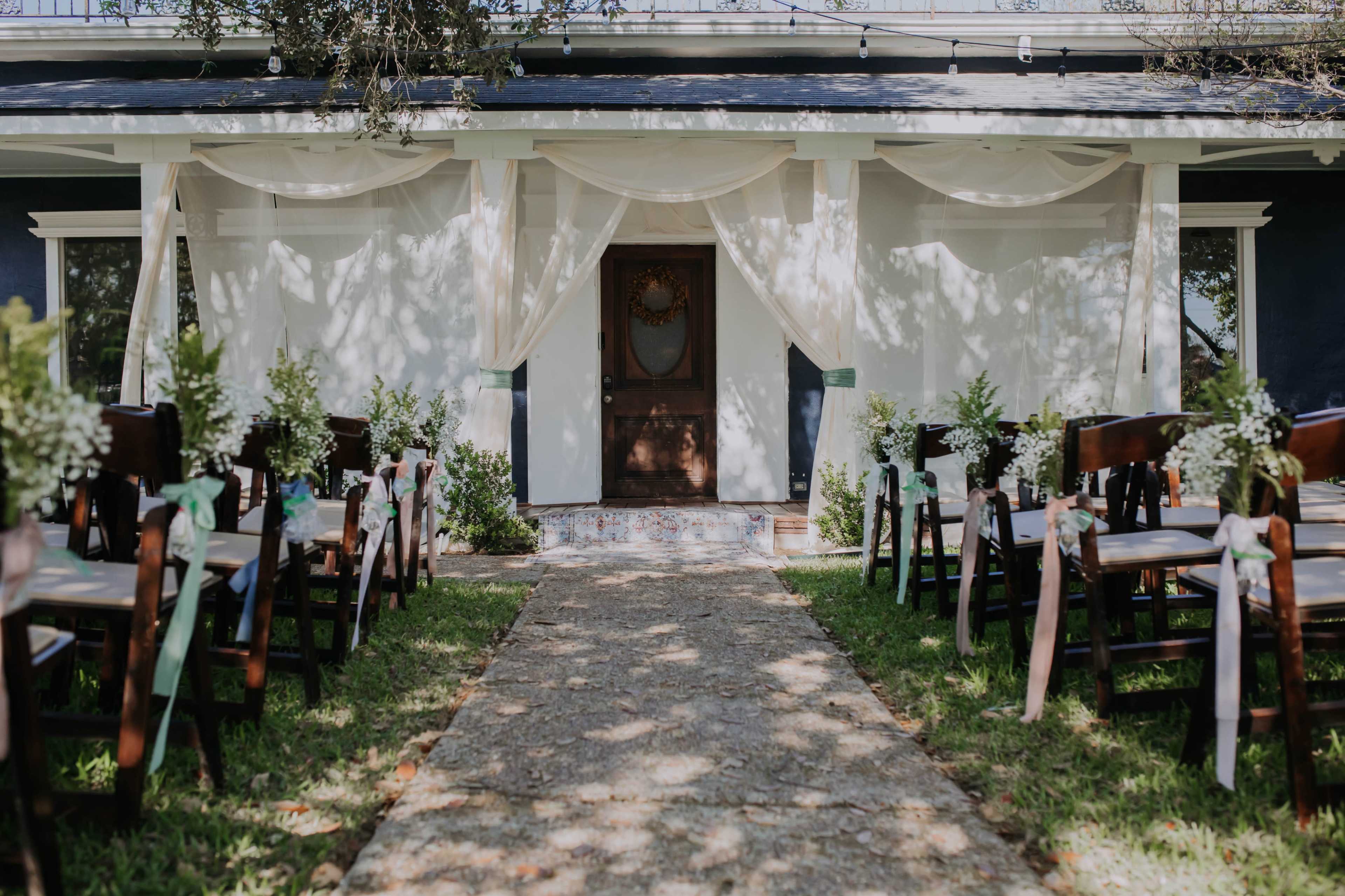 A pathway leads to a decorated entrance with chairs arranged on either side, ready for a ceremony.