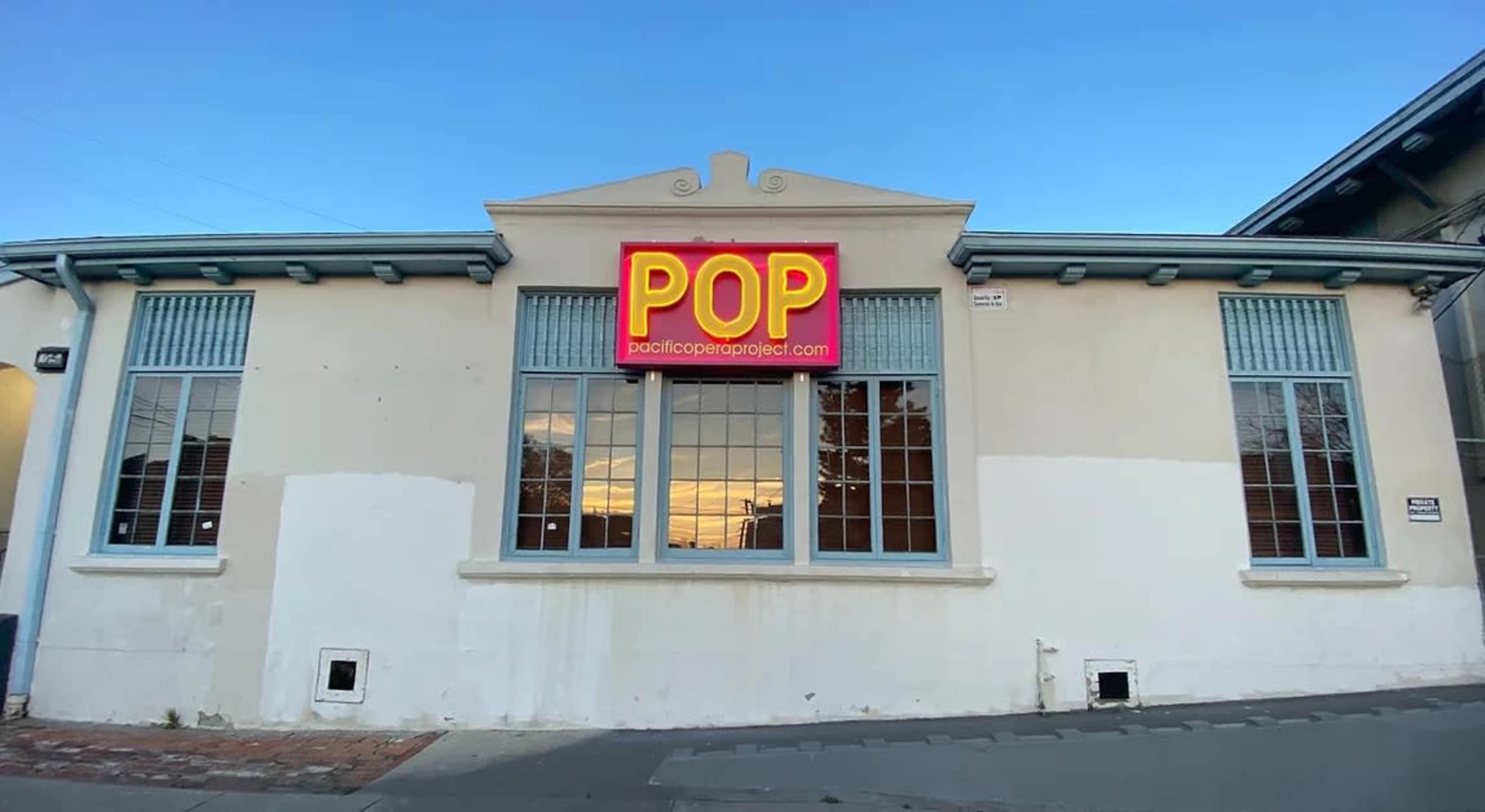 A building with large windows and a prominent sign reading "POP" above the entrance.