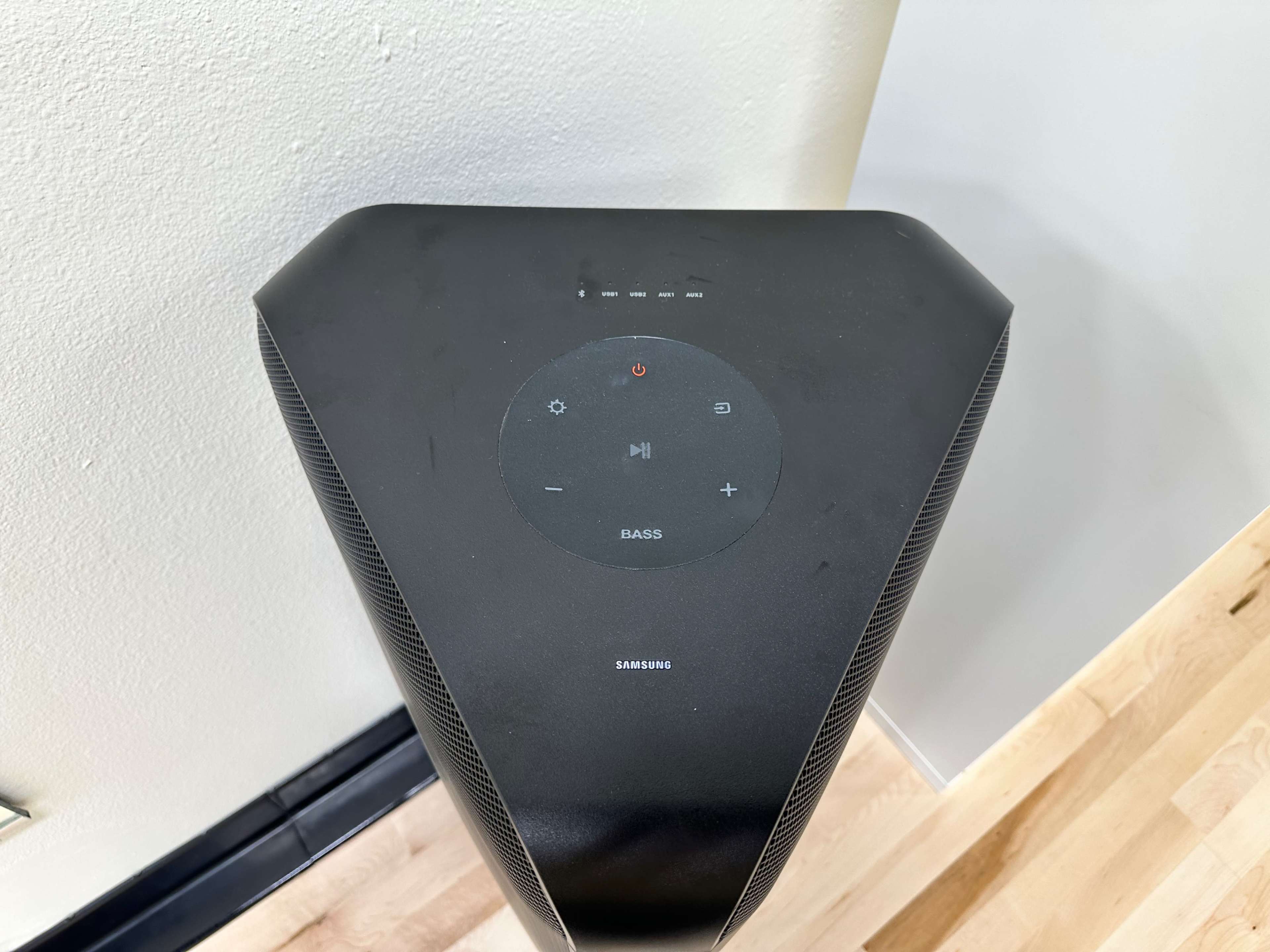 The top view of a triangular-shaped black speaker with control buttons and indicators.