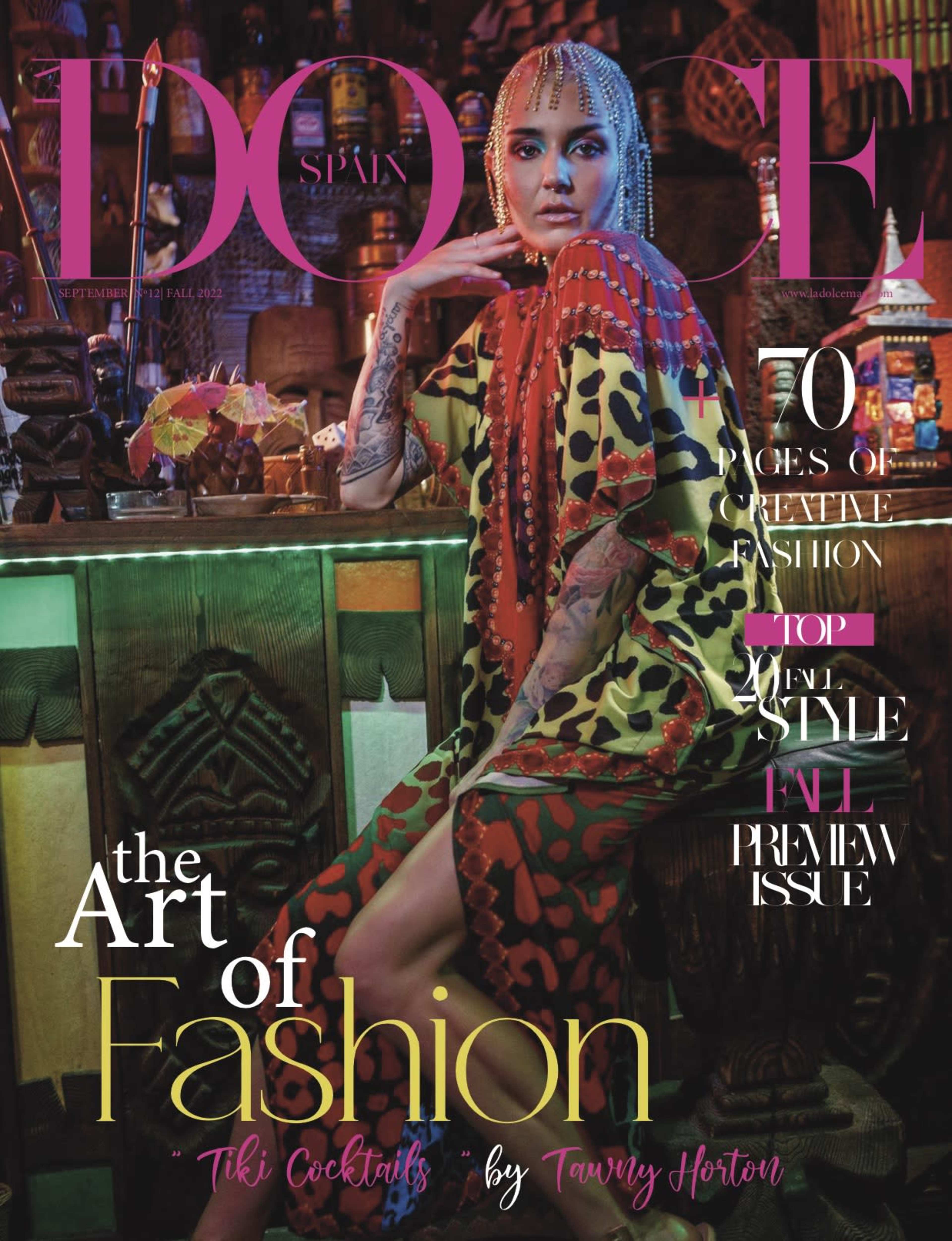 The magazine cover features a woman posed in a vibrant, patterned outfit against a stylishly decorated bar with colorful lighting.