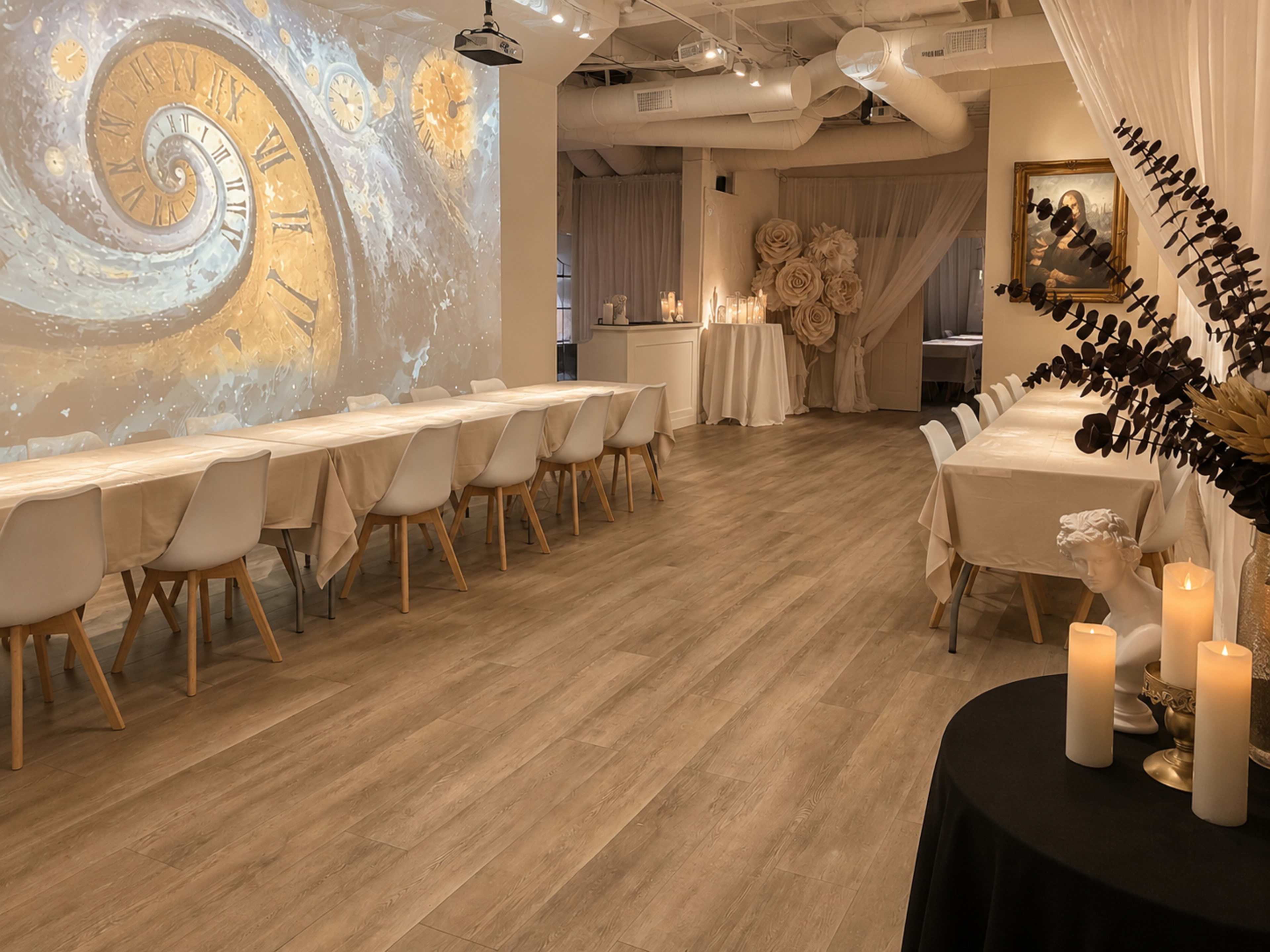 The image shows a spacious event room with a long, table set arrangement, decorative wall art featuring a swirling clock design, and softly lit candles on tables.