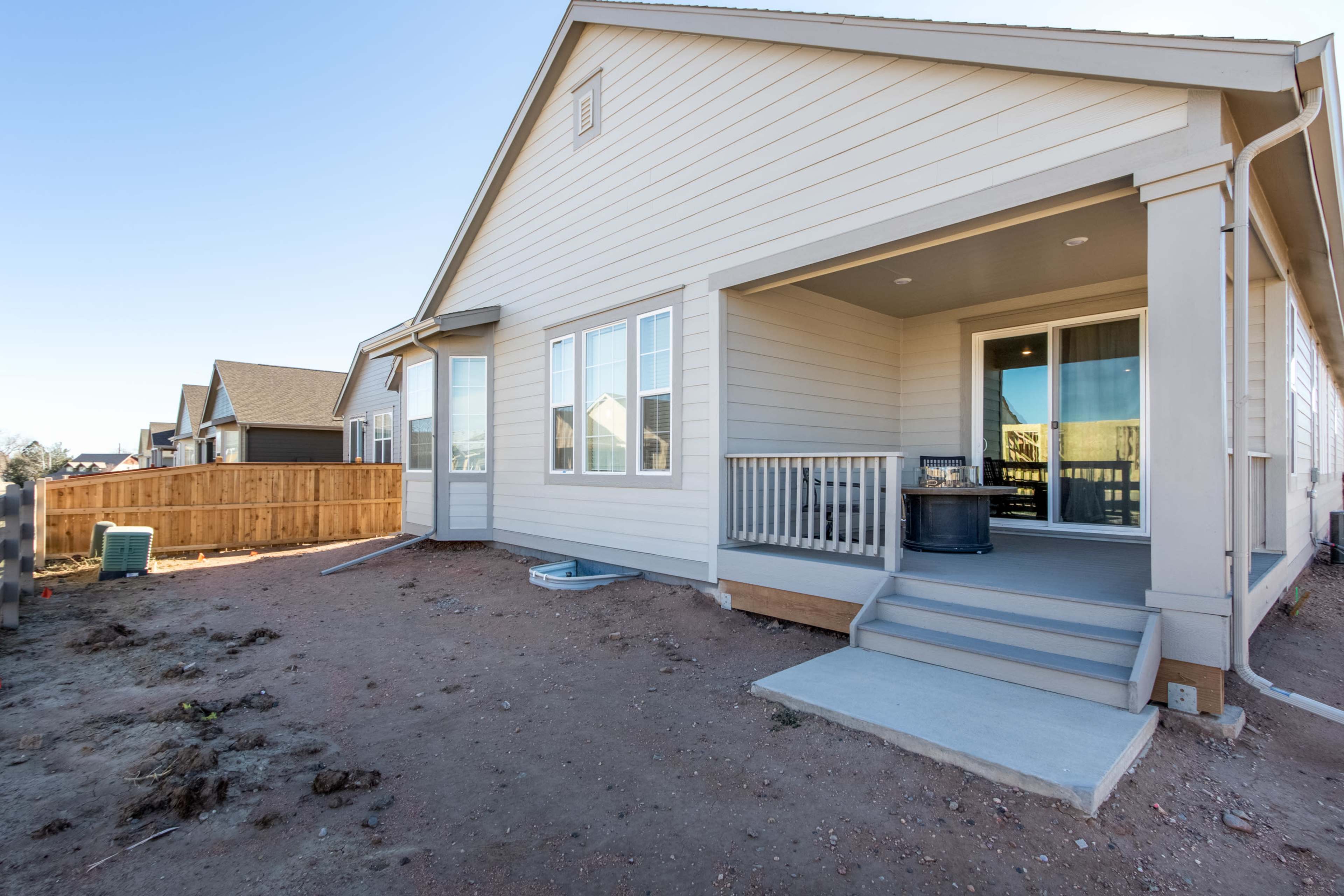 A single-story house with a covered porch and a fenced backyard is depicted.