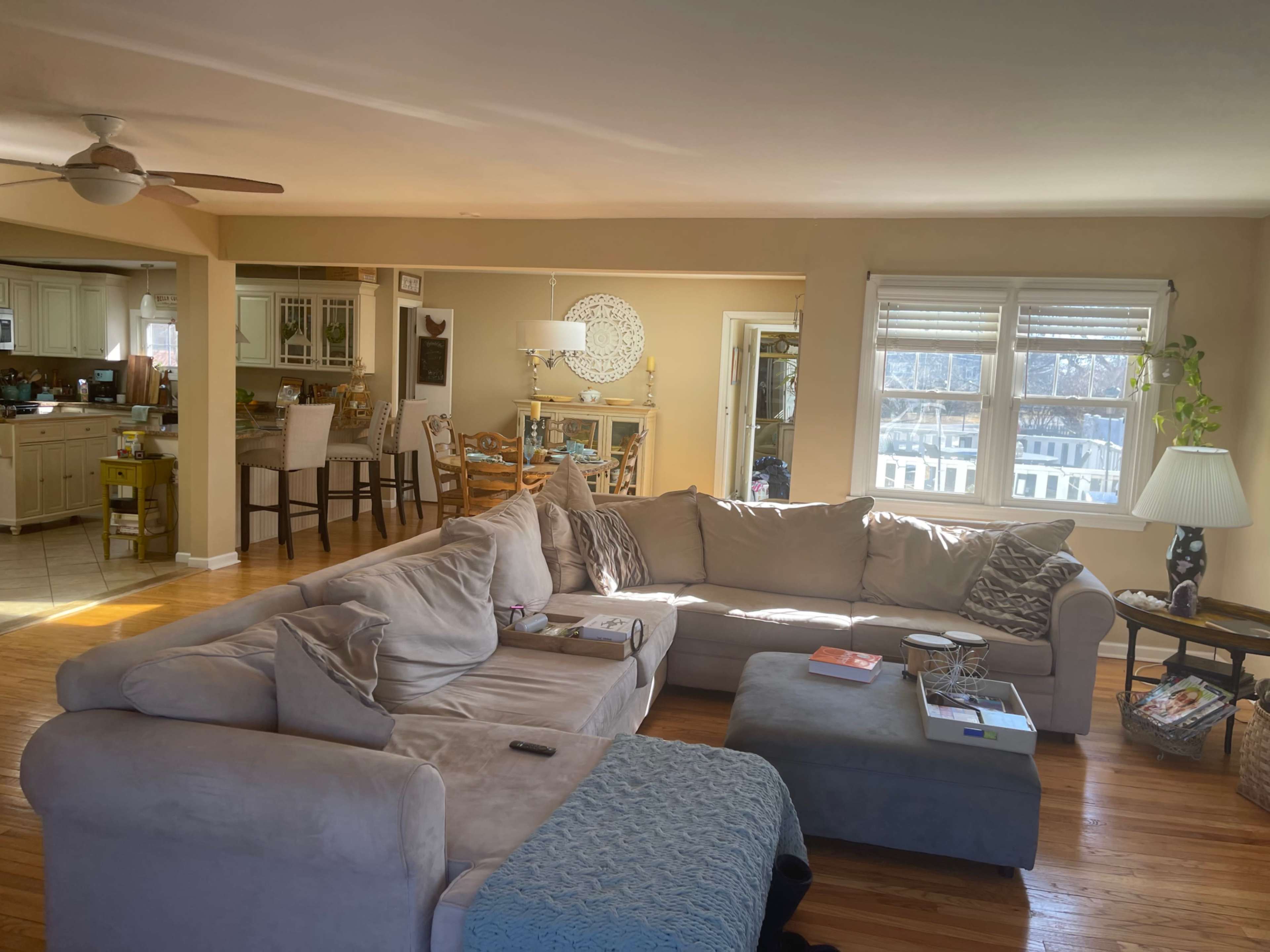 A spacious living room with a large sectional sofa, a coffee table, and a view into a kitchen area.