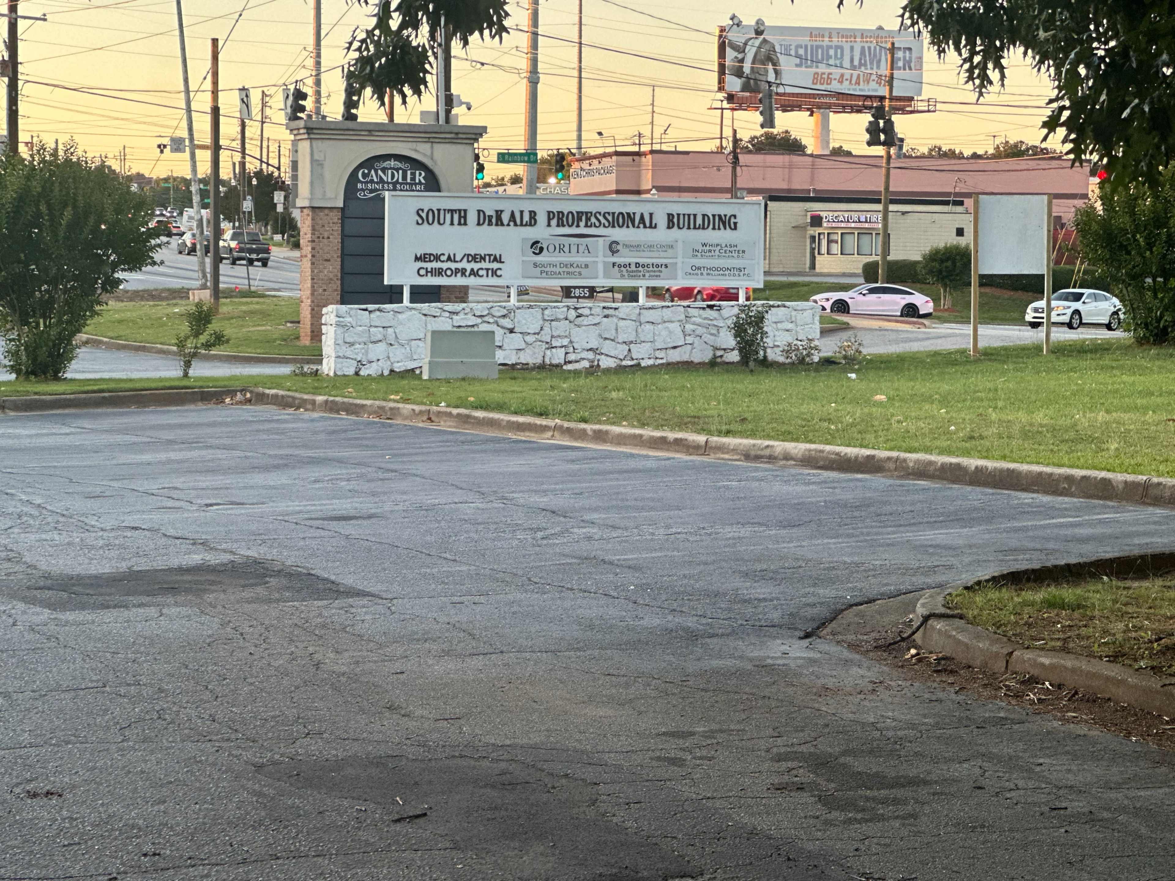 The image shows a sign for the South DeKalb Professional Building, located near a busy intersection with a pink car visible in the background.