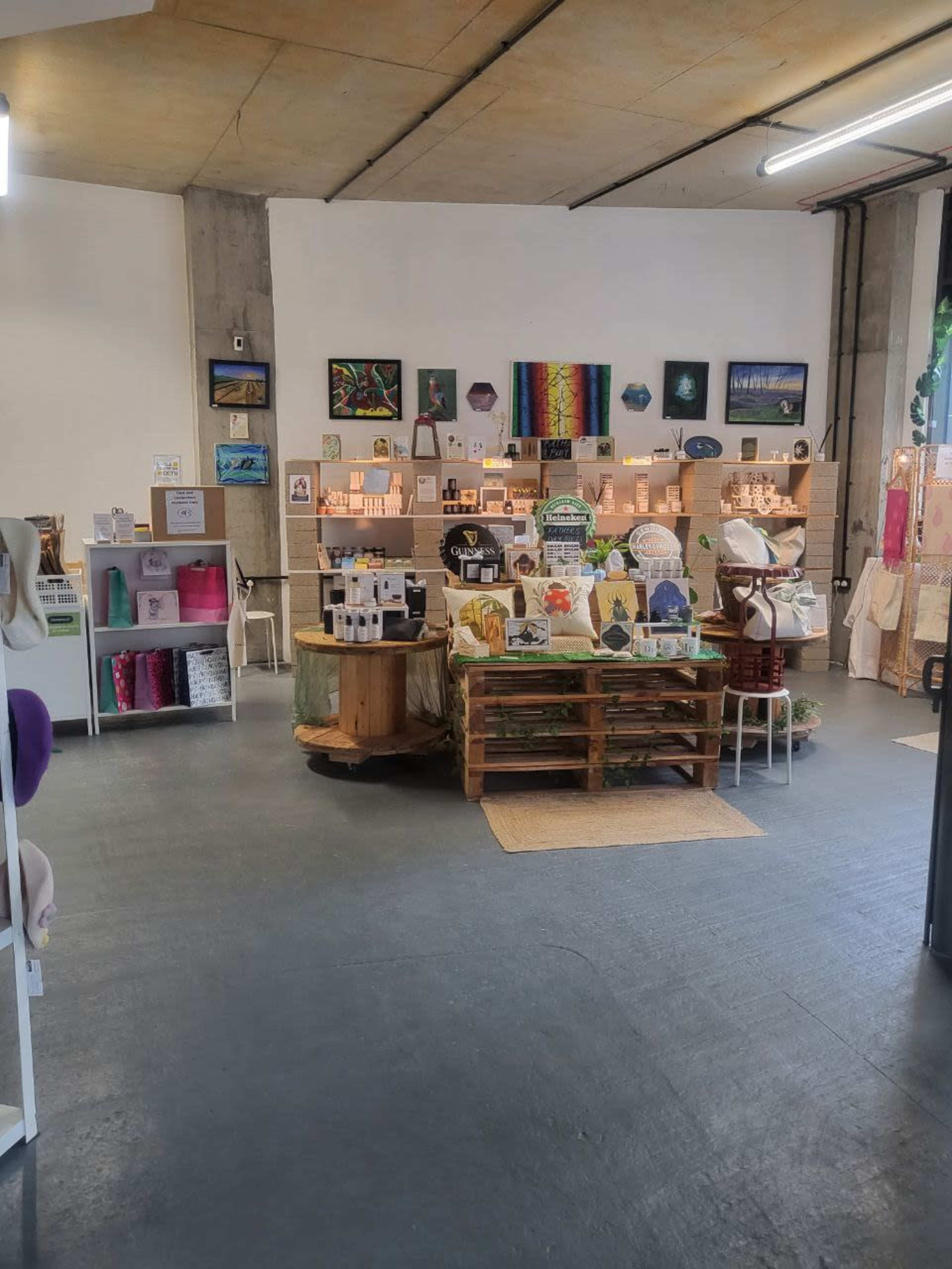 A colorful boutique displays various handmade items and artwork on shelves and tables.