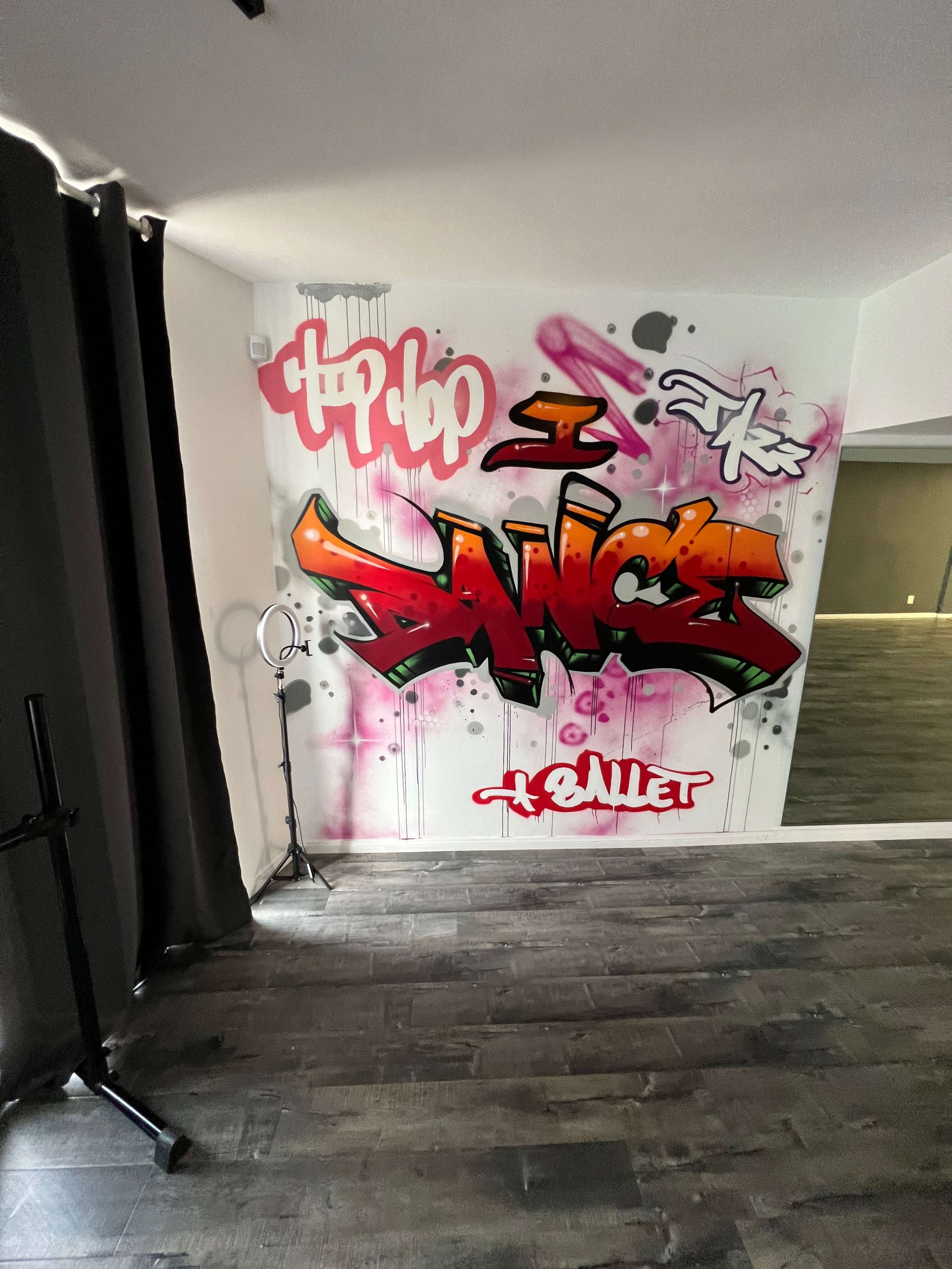A wall featuring vibrant graffiti art that reads "Hip Hop I Dance" with abstract designs and colors.
