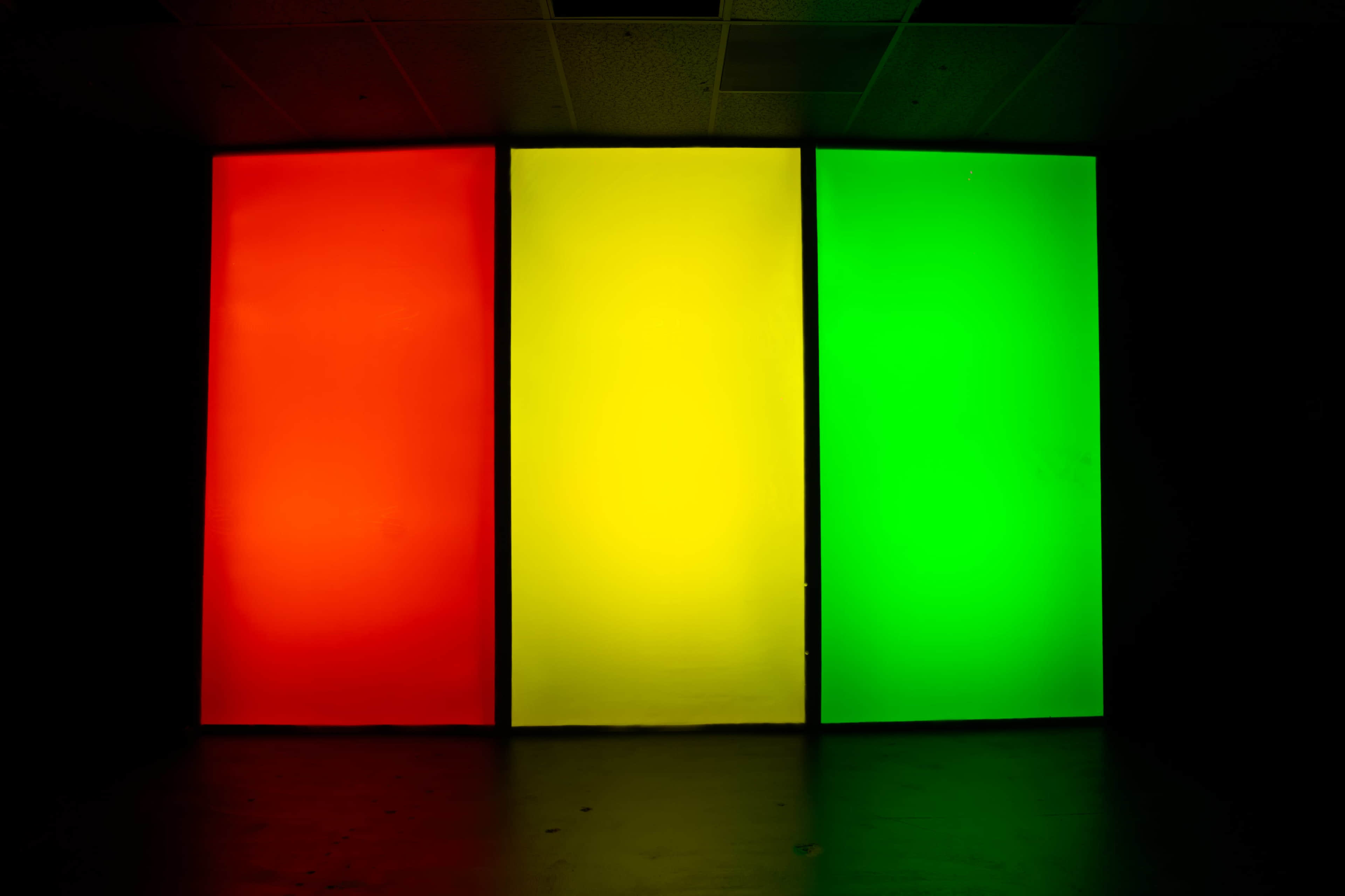 Three vertical panels display red, yellow, and green colors against a dark background.