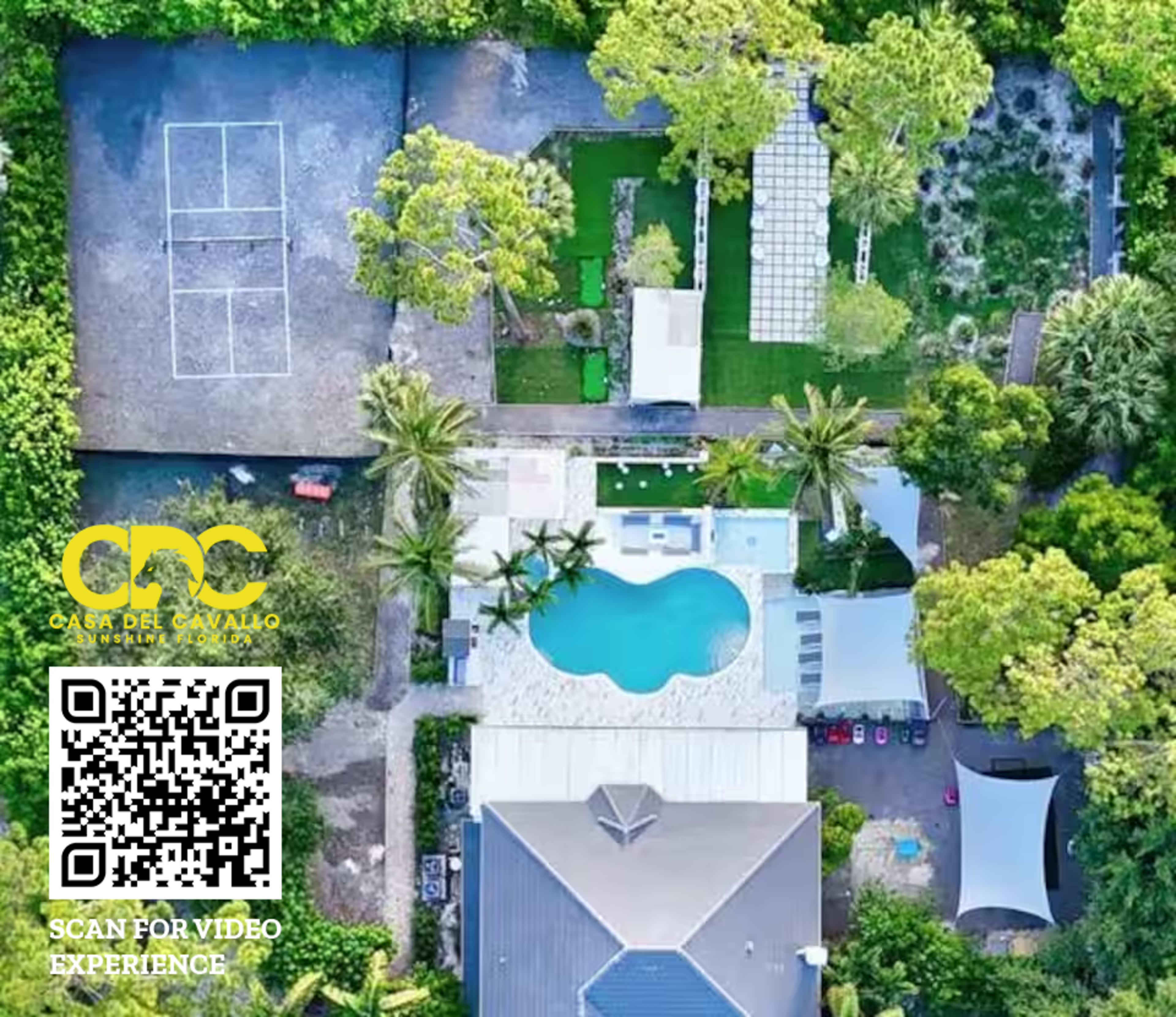 The image shows an aerial view of a property featuring a swimming pool, landscaped gardens, and several structures.