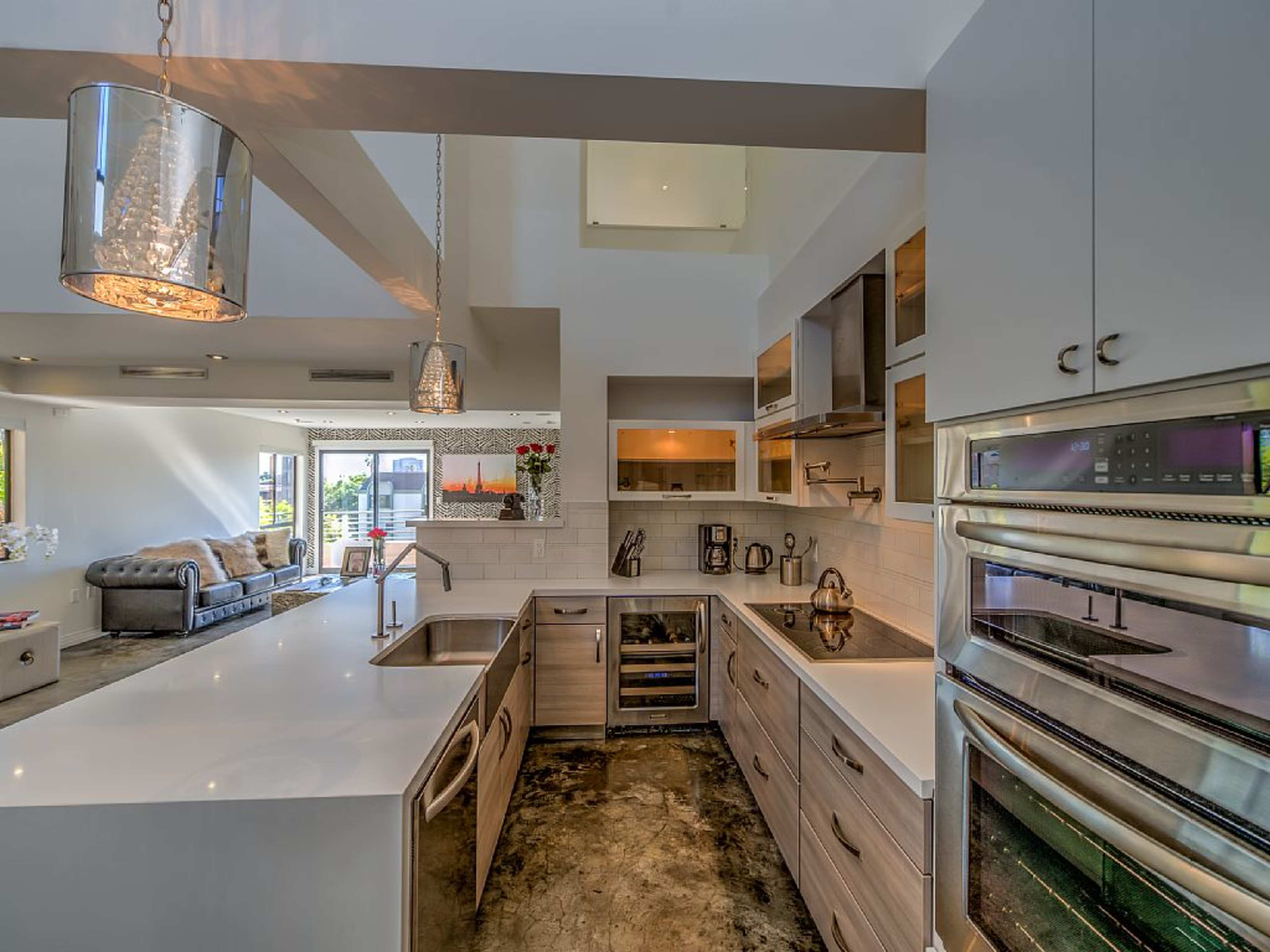 A modern kitchen with a large island featuring a sink, surrounded by sleek cabinetry and stainless steel appliances.
