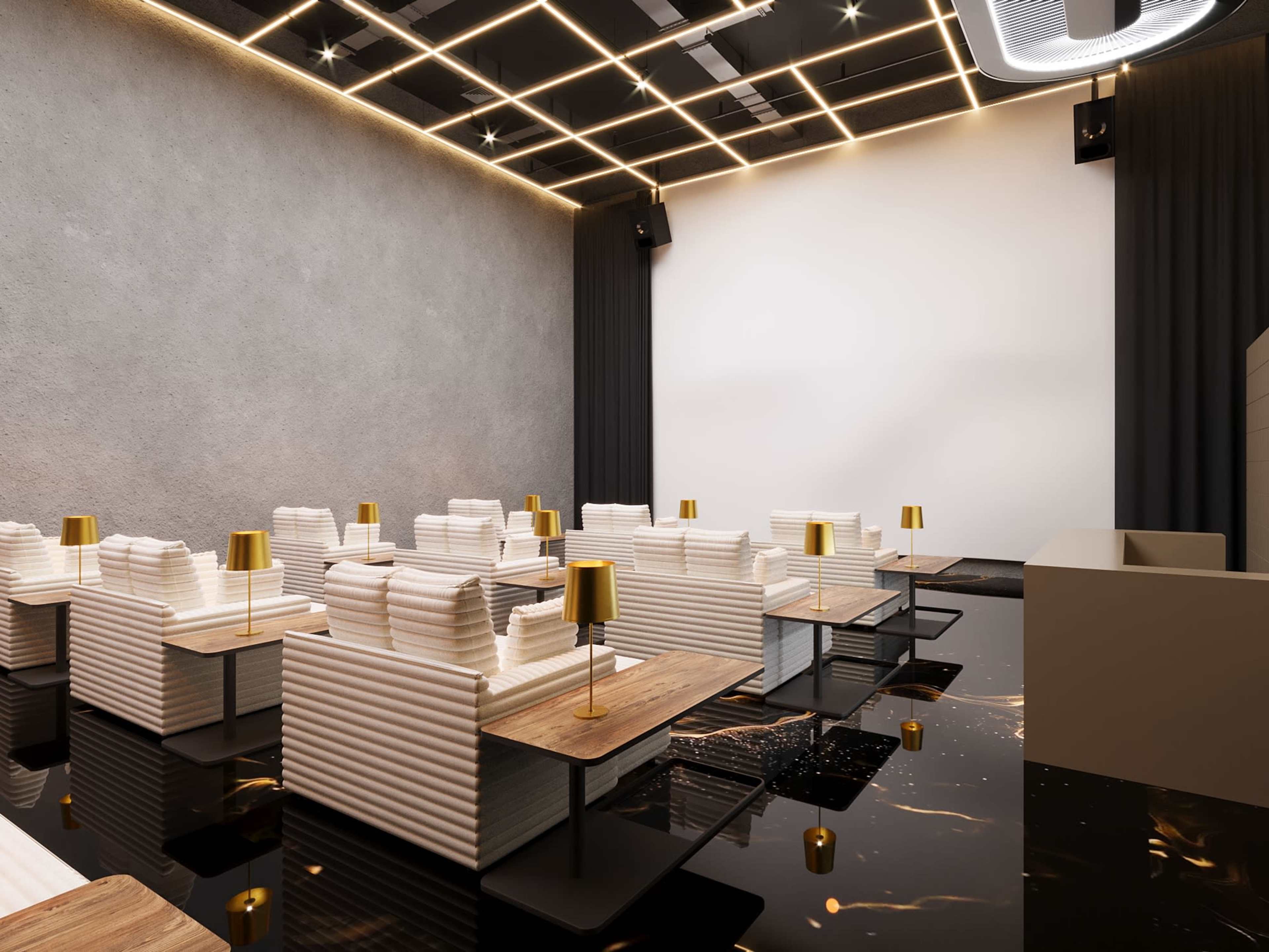 The image shows a modern cinema lounge featuring white lounge chairs with wooden tables and golden lamps under a grid of ceiling lights.