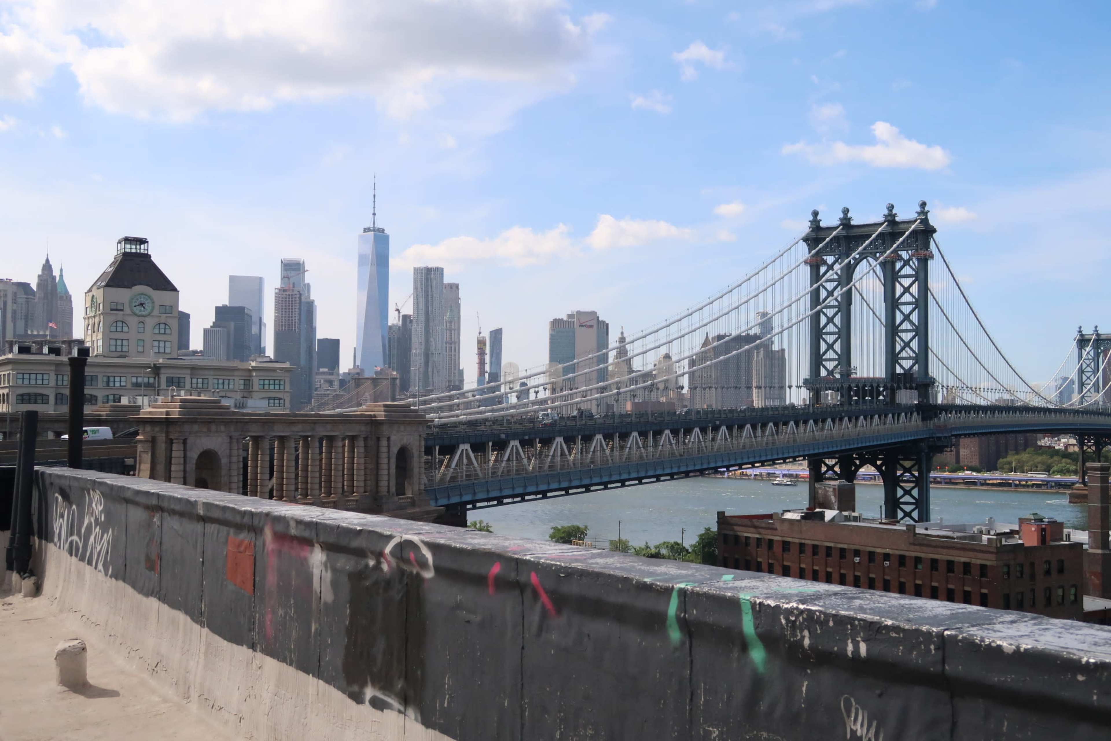The Manhattan Bridge with the New York City skyline in the background, including One World Trade Center.