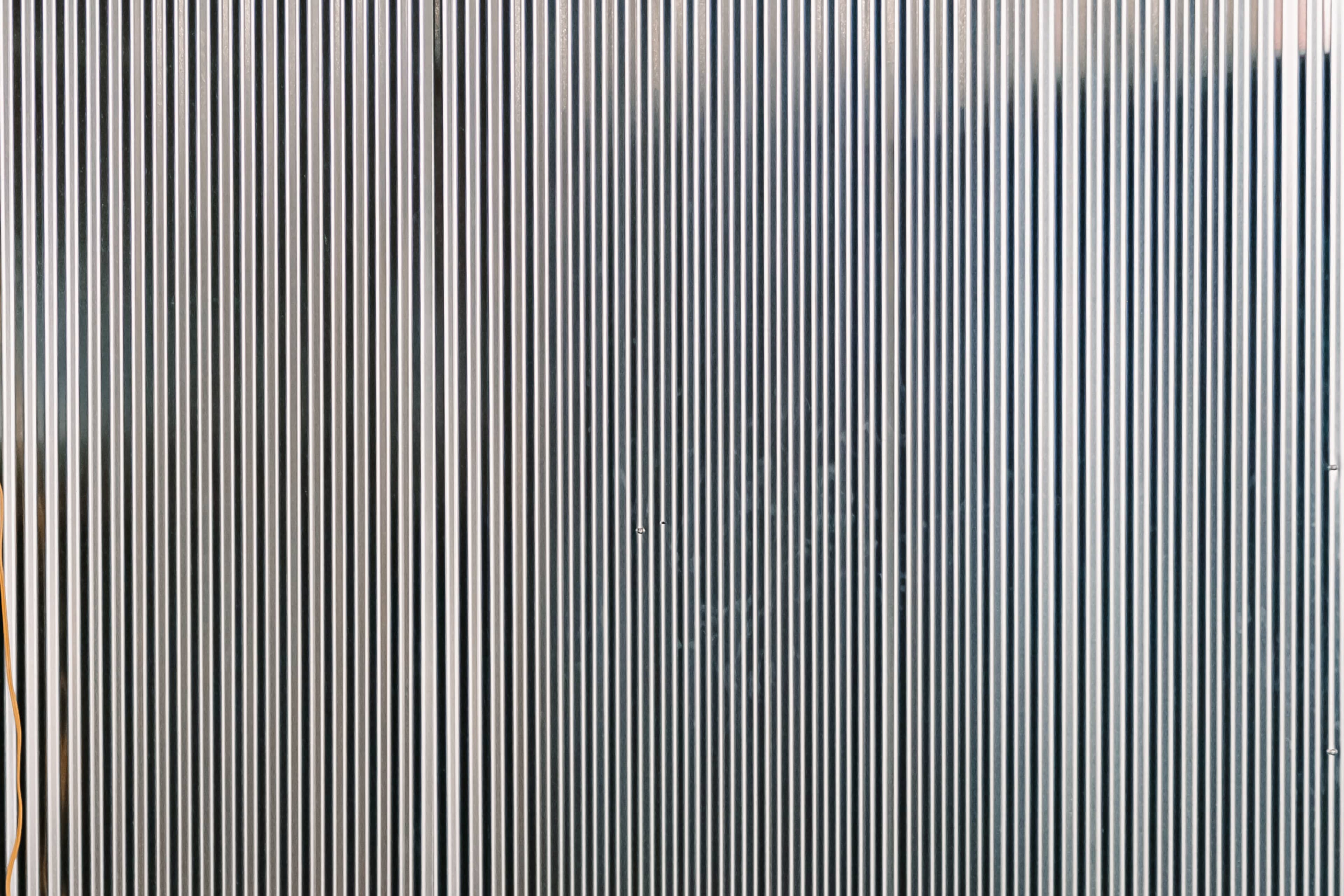 The image features a flat surface covered with vertical metal stripes.