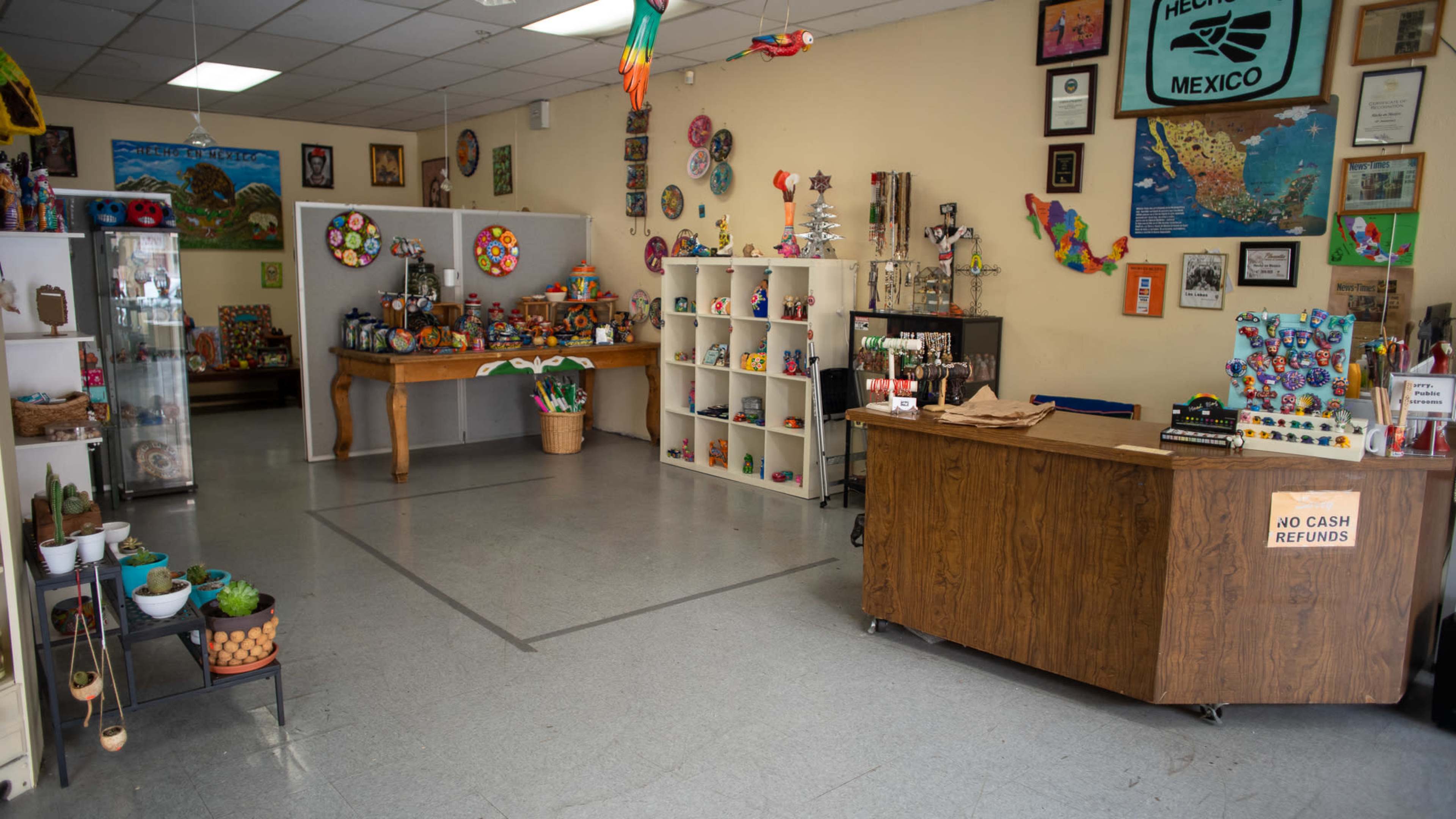 A colorful gift shop featuring various handmade crafts, decorations, and local artwork displayed on the walls and shelves.