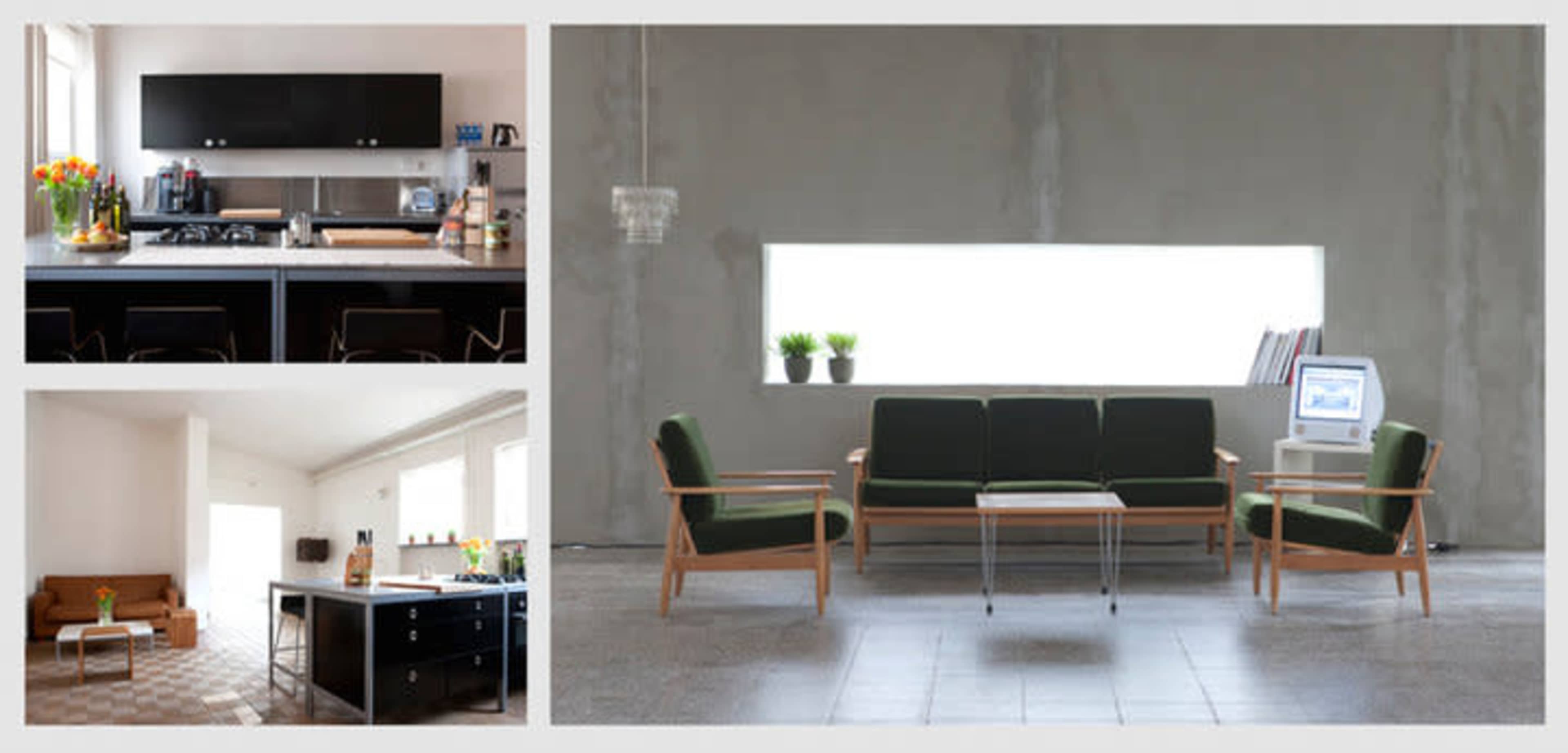 A modern interior space featuring a minimalist kitchen, a living area with a couch, and a seating arrangement centered around a table, illuminated by natural light from large windows.