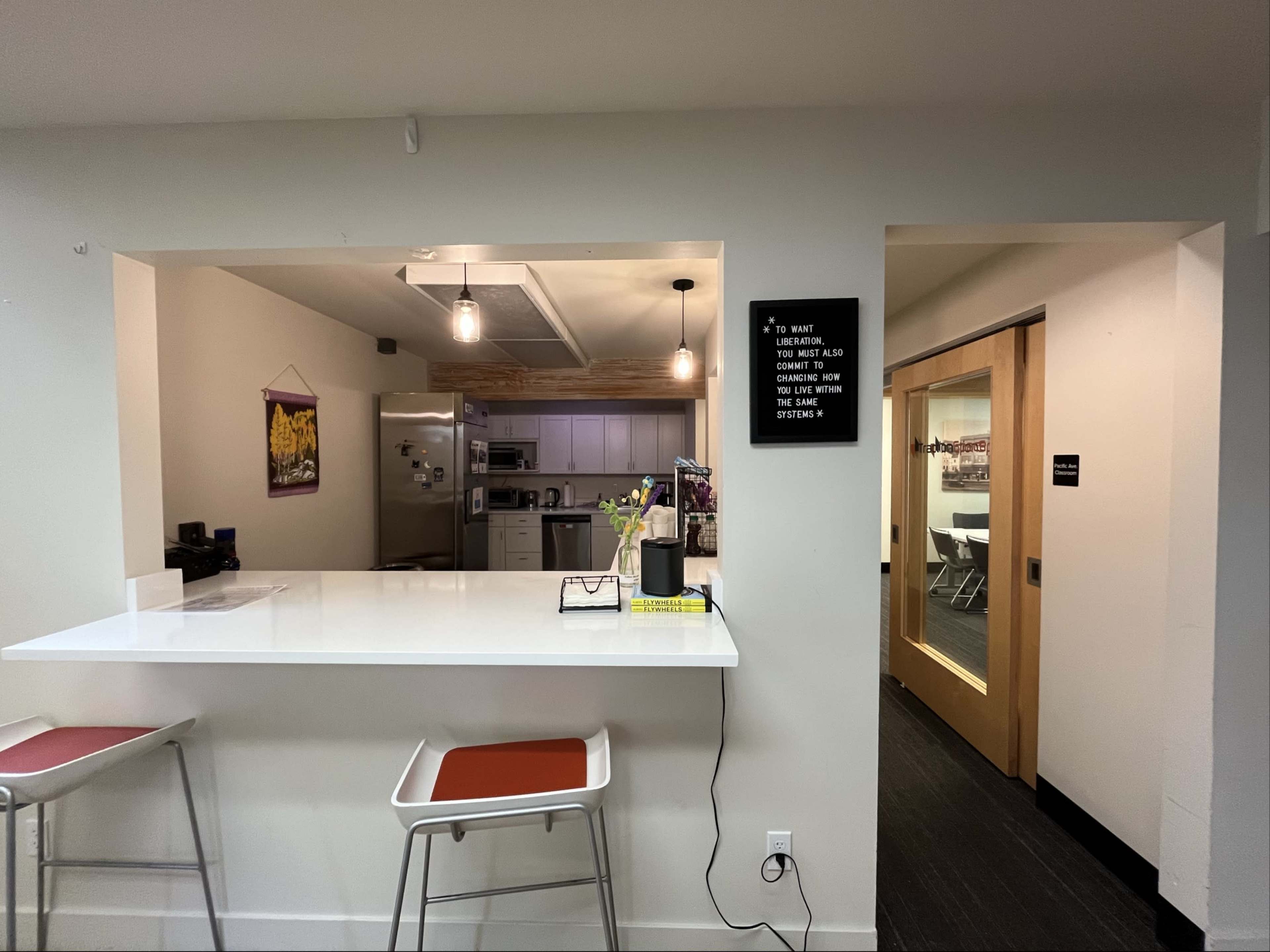 The image shows a modern kitchen with a bar area, leading to a hallway with a door marked "Conference Room."