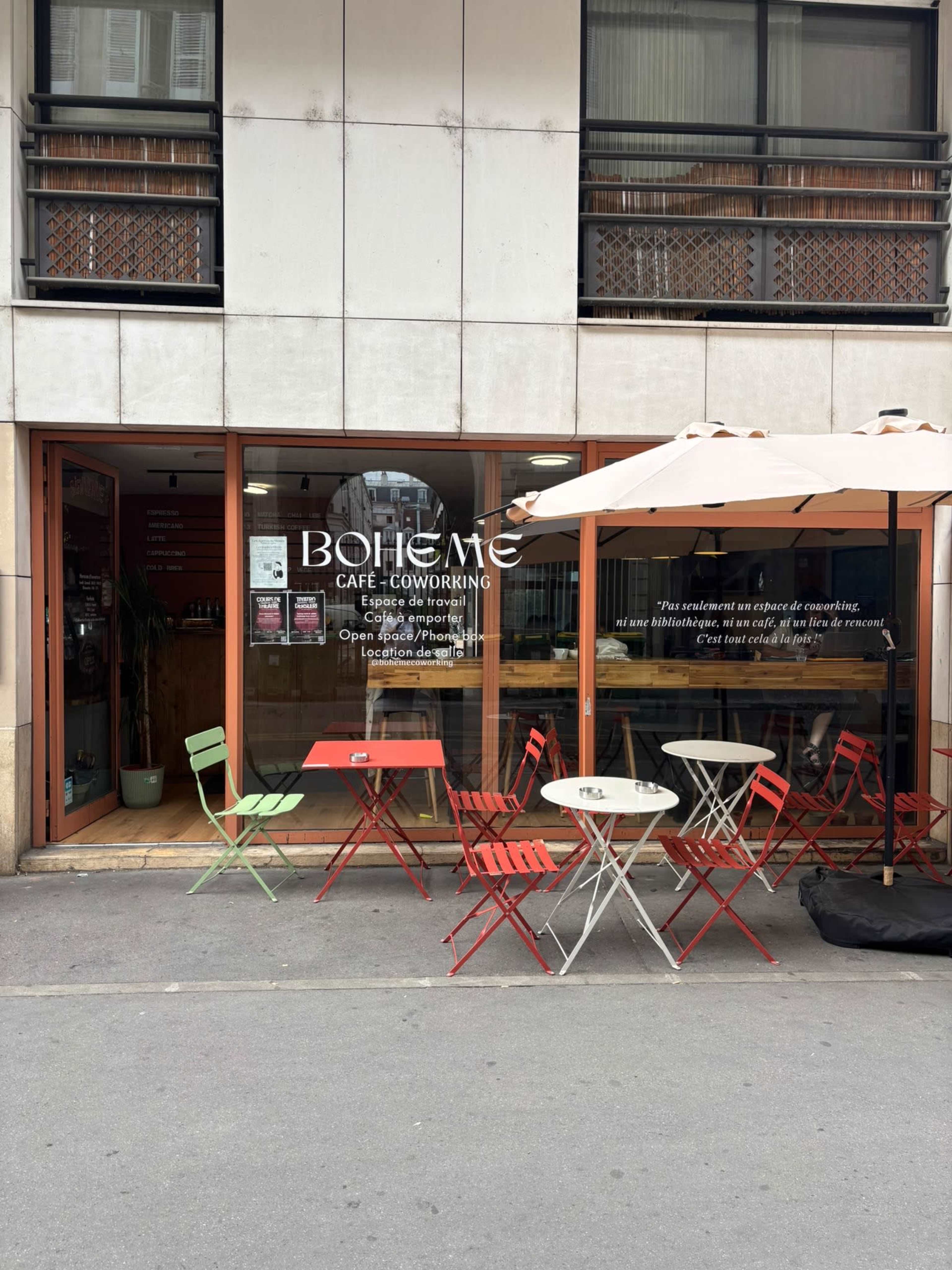 The image shows a café named "Bohème" with outdoor seating consisting of red and green chairs and small tables on a city street.