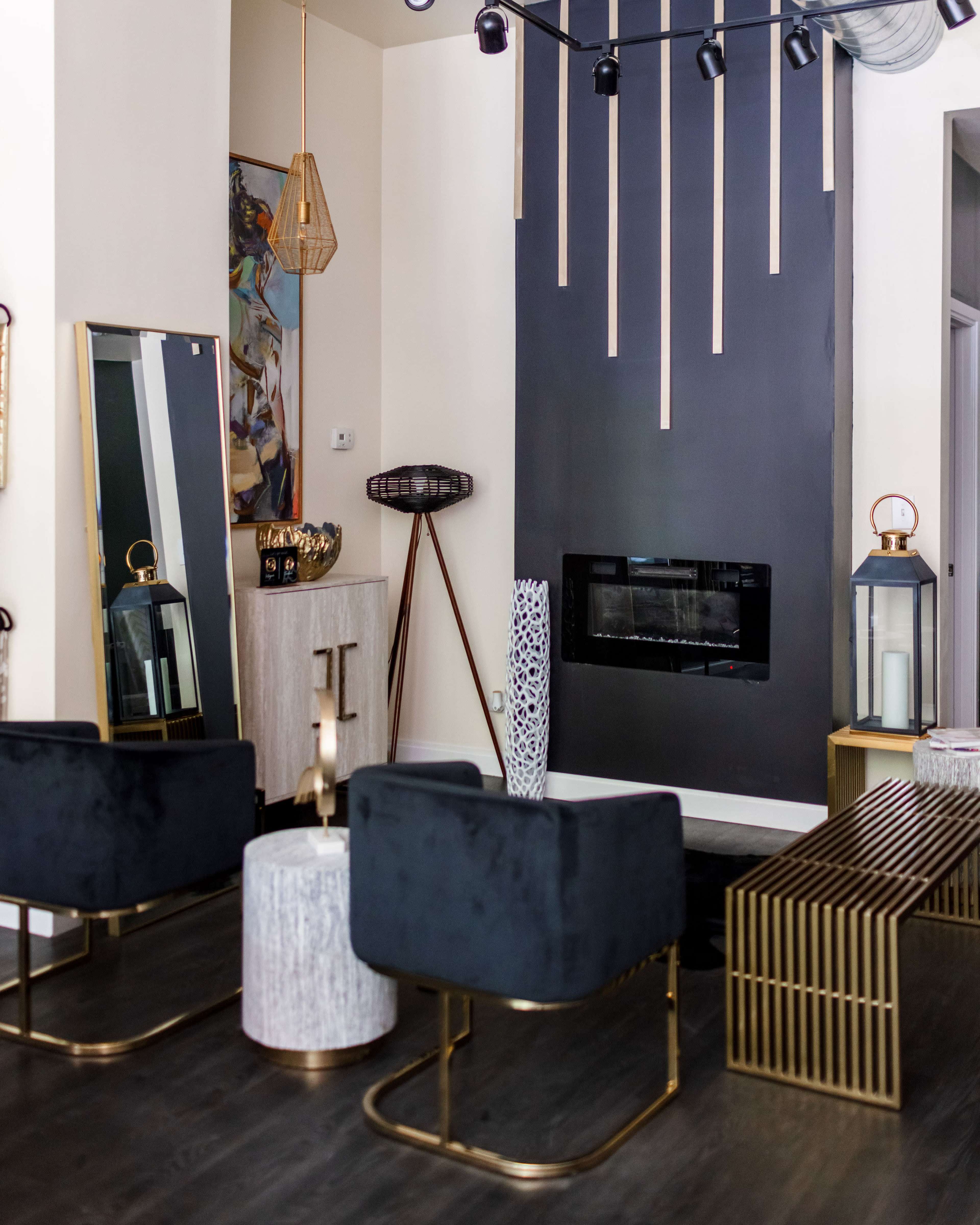 A modern living room with a dark accent wall, contemporary furniture, decorative lighting, and a fireplace.