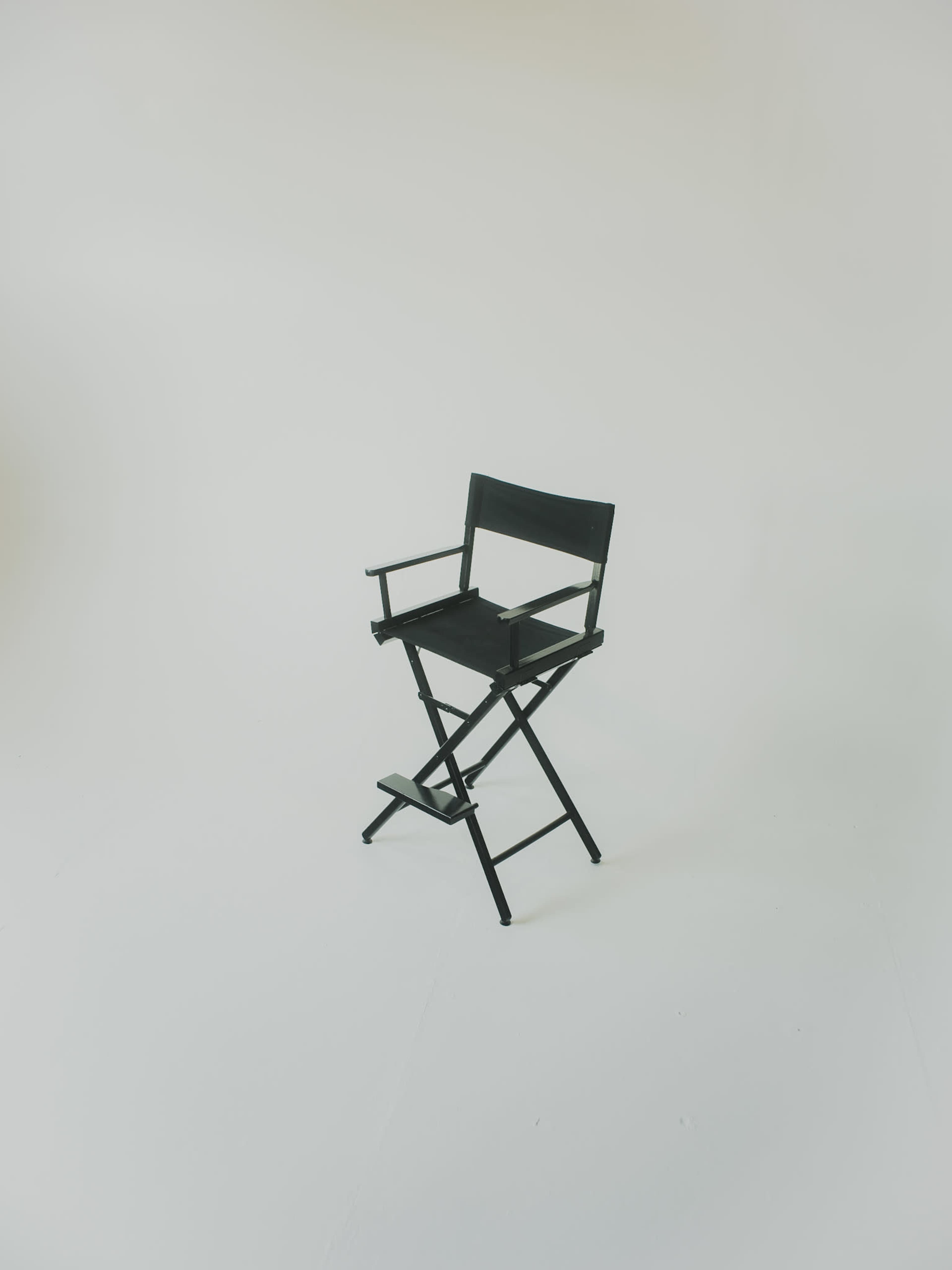 A black director's chair is placed against a plain white background.
