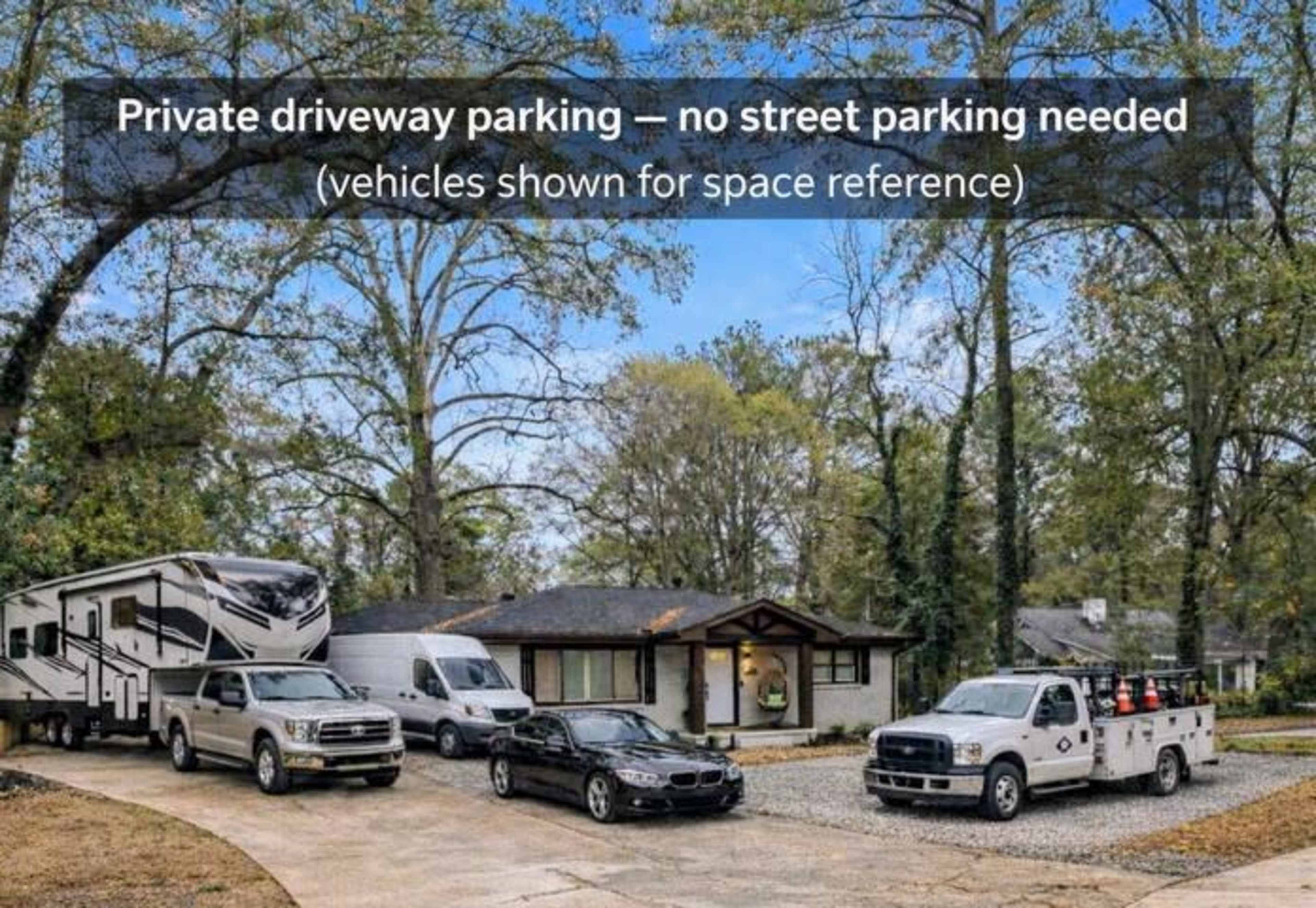 The image shows a residential driveway with multiple parked vehicles, including a recreational vehicle and several trucks, in a suburban setting.
