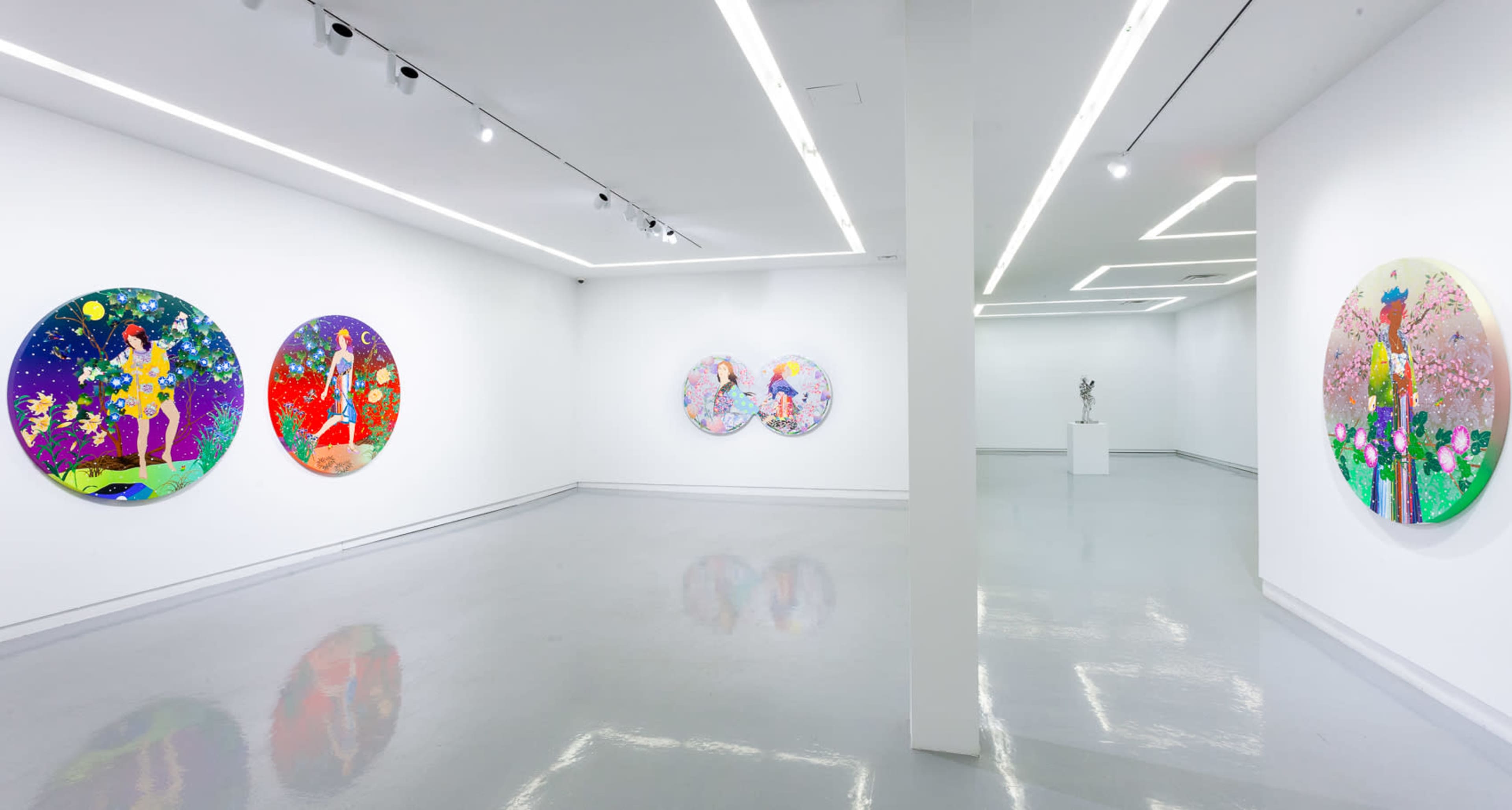 The image shows an art gallery with four circular paintings on the walls, a sculpture in the center, and bright white lighting.
